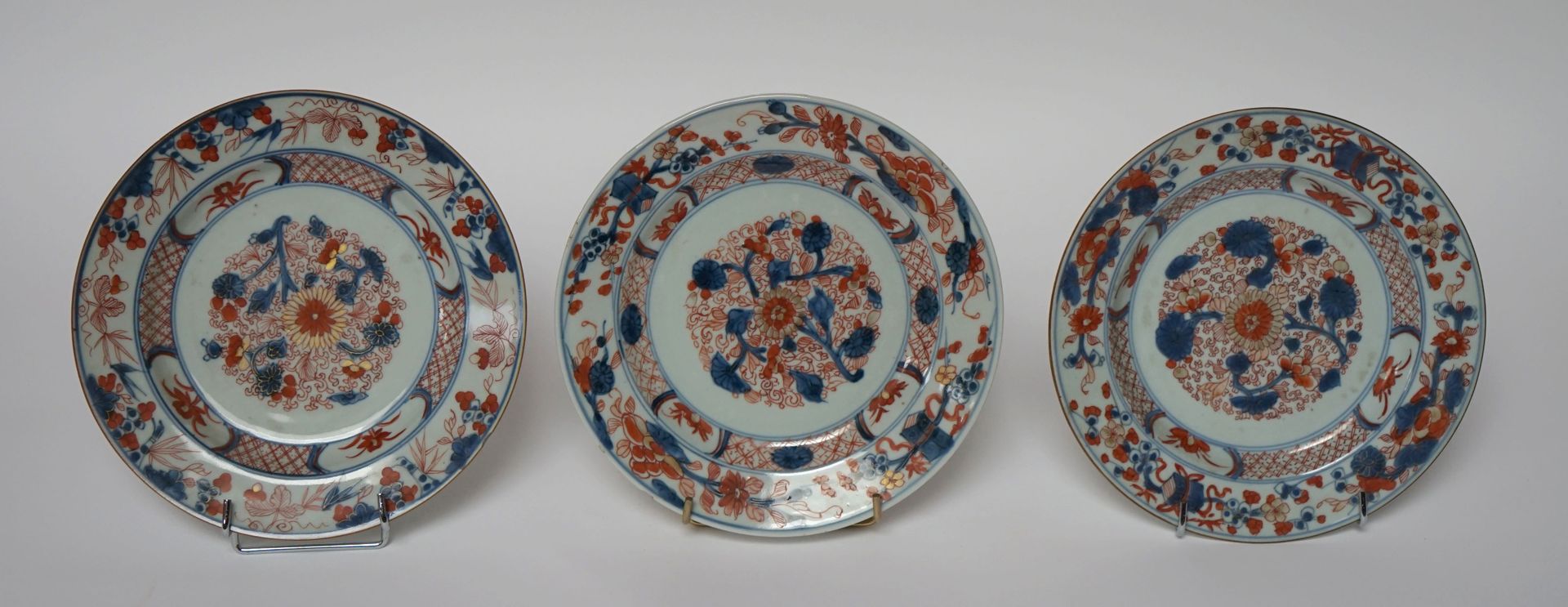Null 中国，18-19世纪。三个日本风格的伊万里瓷盘，有蓝红色和金色的花卉装饰。(小碎片)。D. 22,5 cm