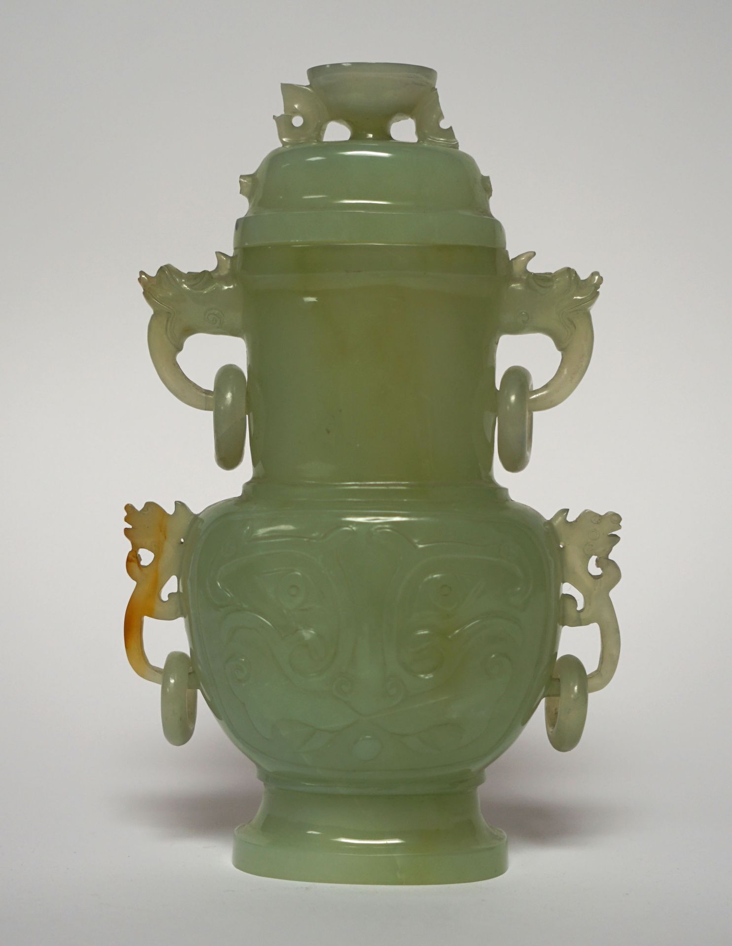 Null 中国。覆盖玉石的花瓶，瓶身饰有饕餮面具的造型，手柄上刻有大量的圆环。高20厘米。事故，一些元素要被粘回去。