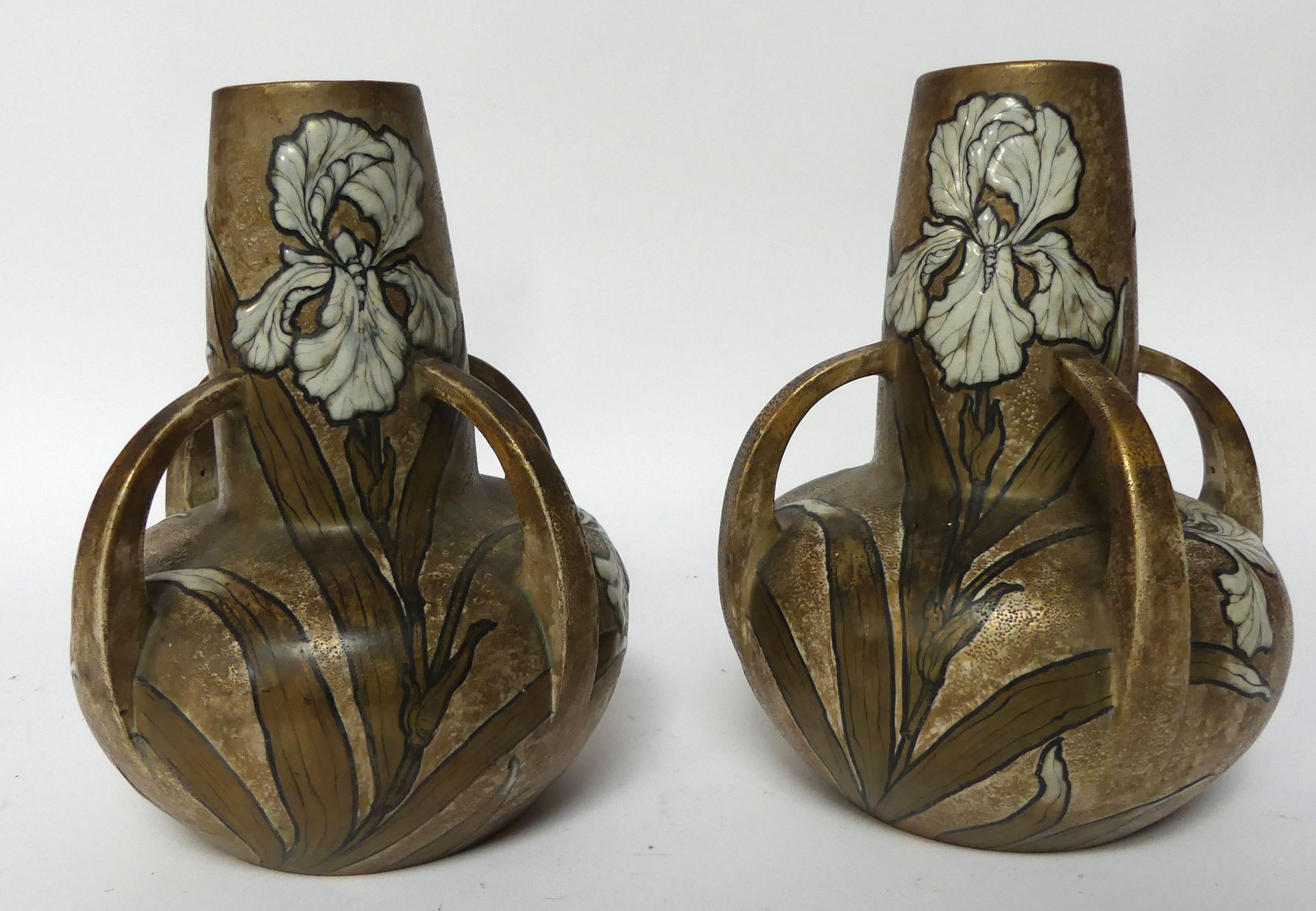 Null 转向特普利茨，奥地利。一对釉面陶瓷花瓶，低矮的瓶身有四个把手，在沙色和轻度镀金的背景上装饰着白色鸢尾花。高26厘米。