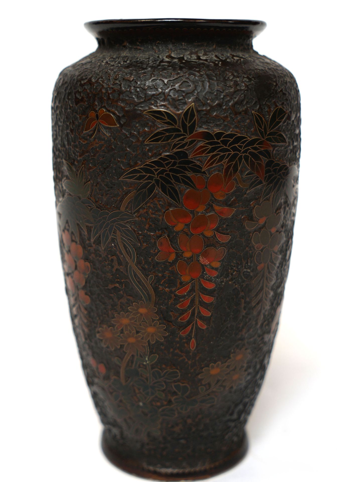 Null 日本。瓷器花瓶，在巧克力浮雕背景上用金属景泰蓝装饰着紫藤和蝴蝶（非常轻微的缺口）。底座下有一个标记。H. 19厘米。