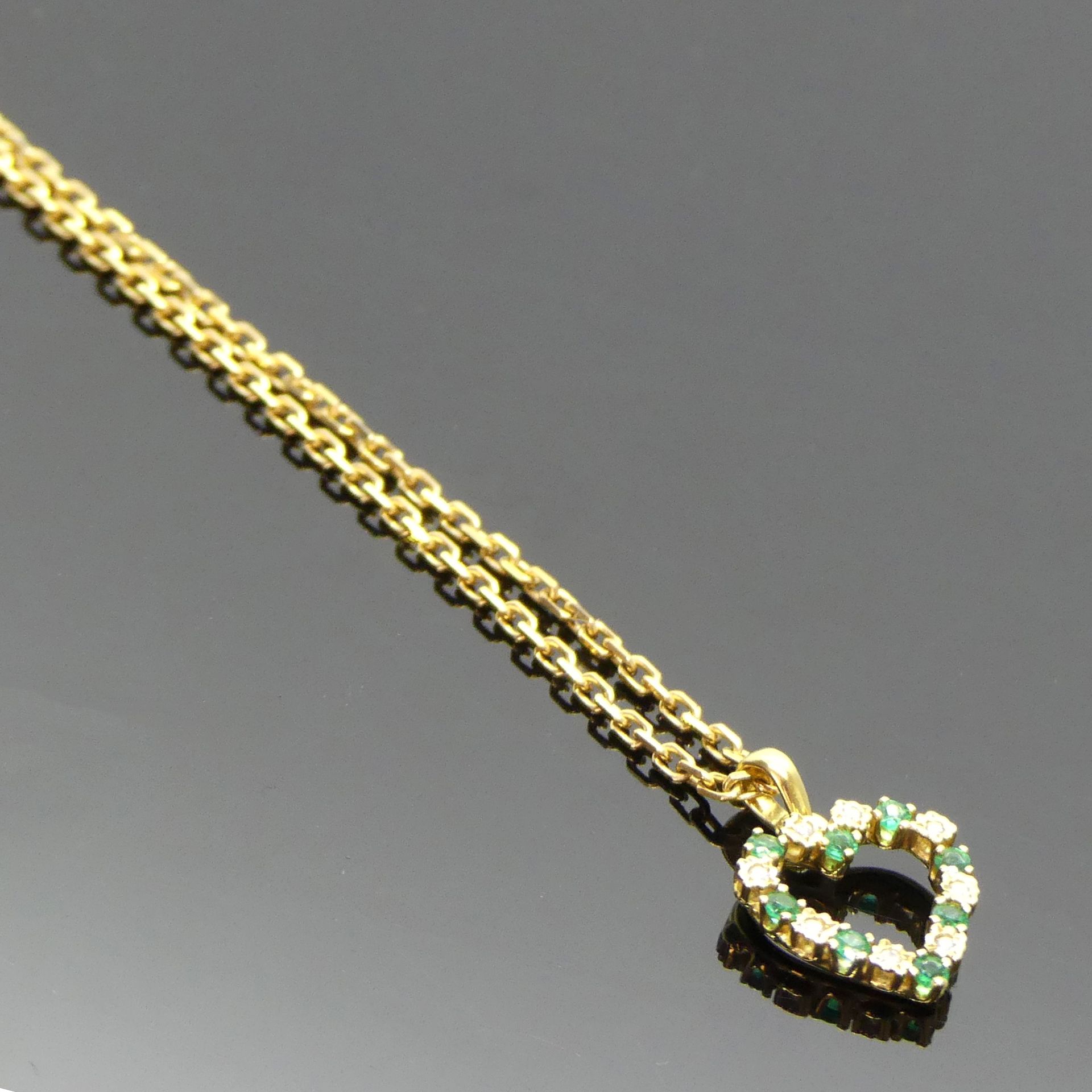 Null 黄金链上有一个镶有钻石和绿宝石的黄金 "心 "吊坠。毛重 8,46 g