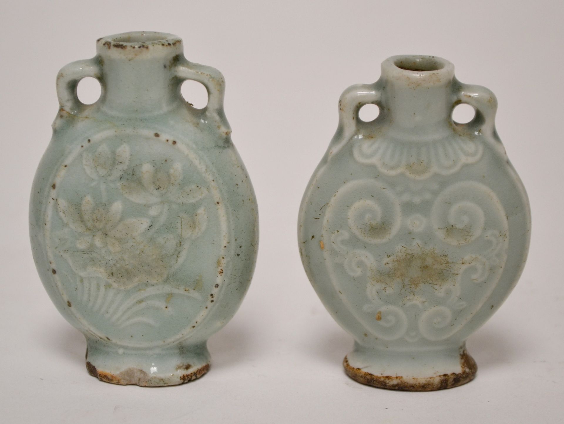 Null 中国。两件青瓷釉面的TABATIERES，带把手，刻有花卉图案的装饰。(发射的一个芯片)。高7,4和7厘米。中国。米色和蓝色釉面炻器中的坐着的字母人，&hellip;