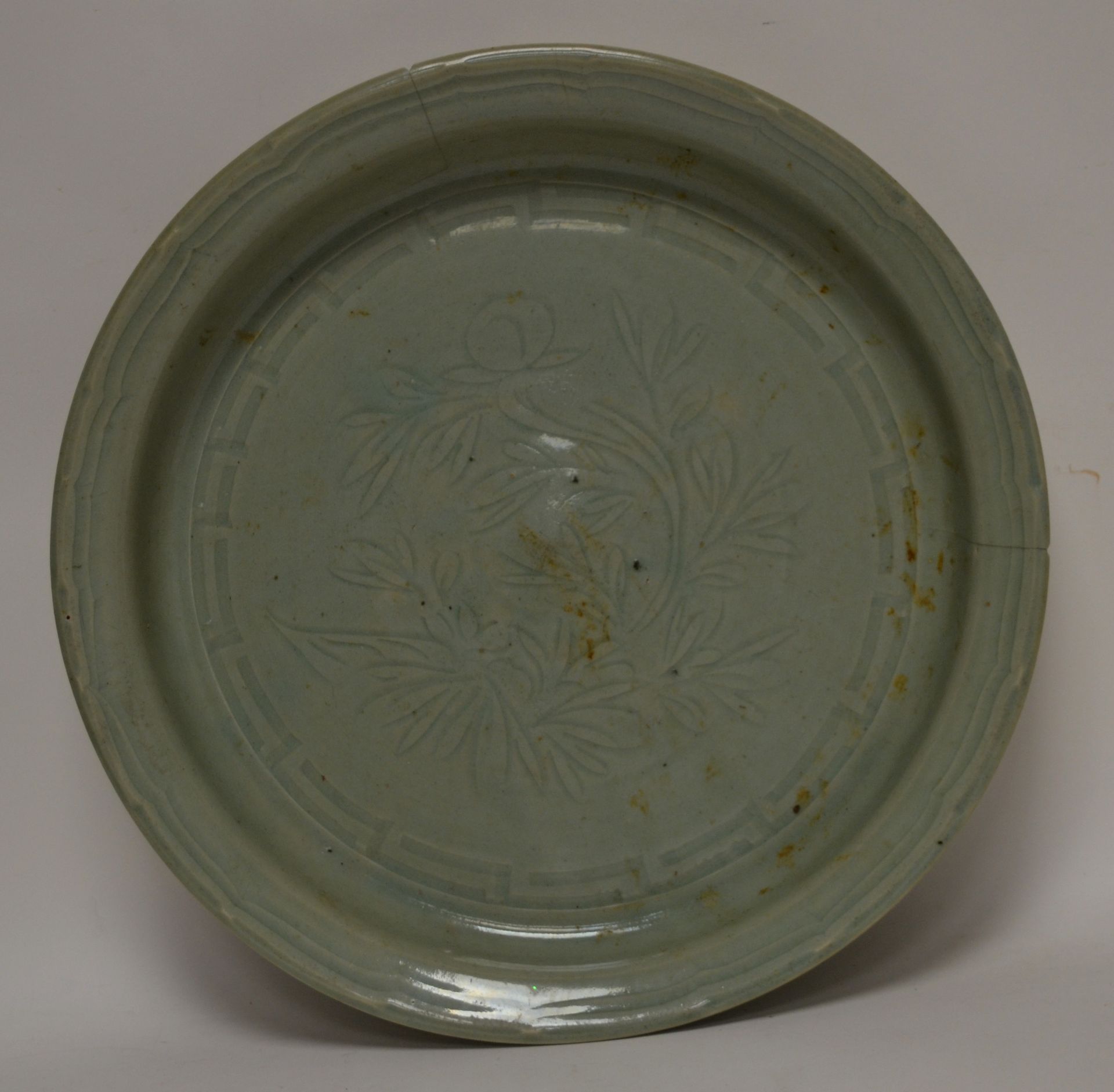 Null 中国，18-19世纪。一个大的青瓷釉圆盘，底部有刻画的树枝装饰，边缘有花边的支架（边缘有两条裂缝和缺口）。D. 43,5 cm