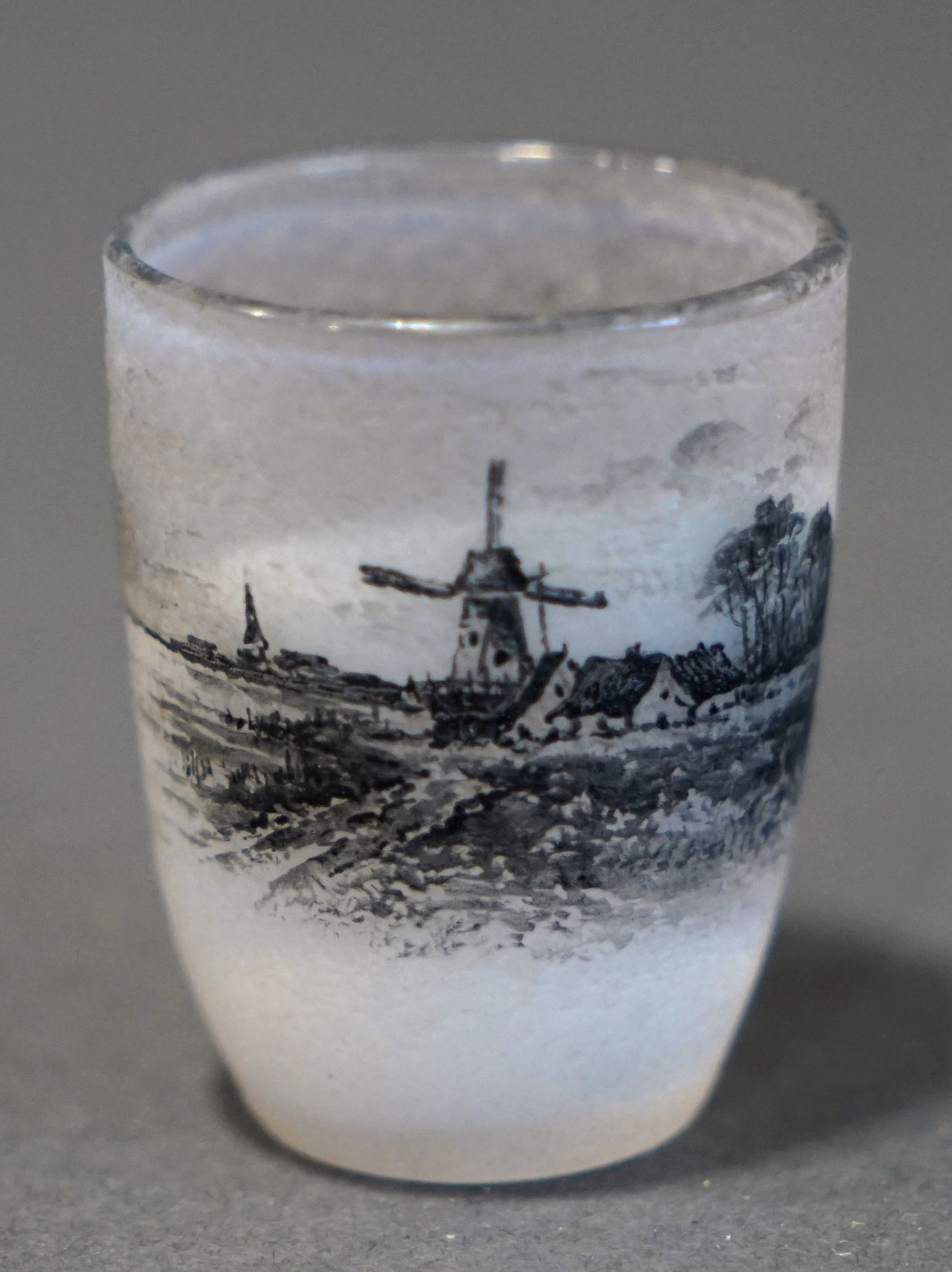 Null DAUM, Nancy.灰色磨砂玻璃小GOBELET，其上的珐琅彩装饰是一个带有磨坊和帆船的湖泊景观。签名。H. 5 cm