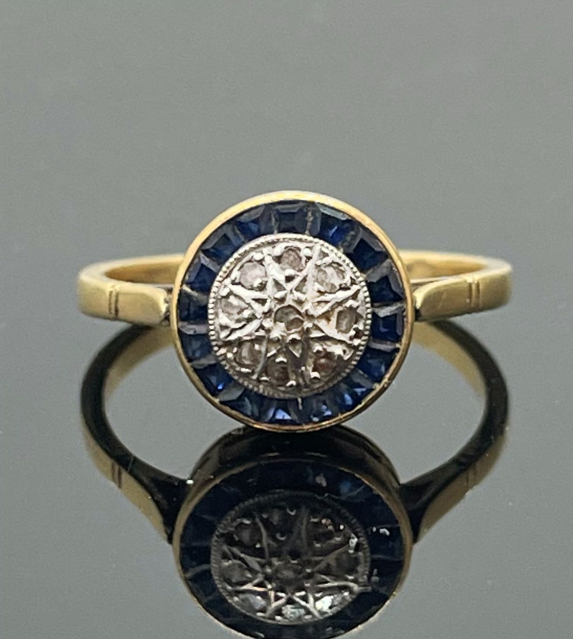 Null 黄金戒指，白金背景的圆形表圈上镶嵌着钻石，周围是校准的蓝宝石。TDD 52。重量2,62克