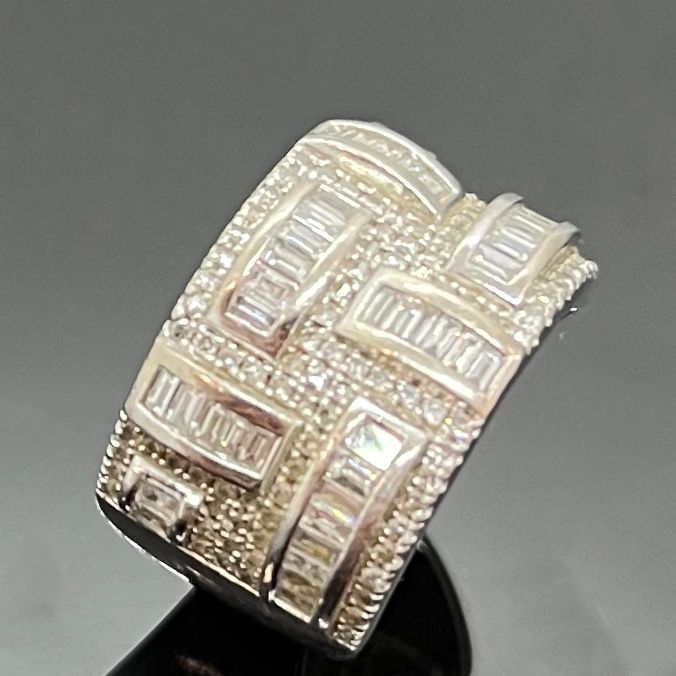 Null 美丽的白金戒指，在圆钻的铺垫上镶嵌着长方形钻石的线条。总重量为8.3克。钻石的重量约为1克拉。