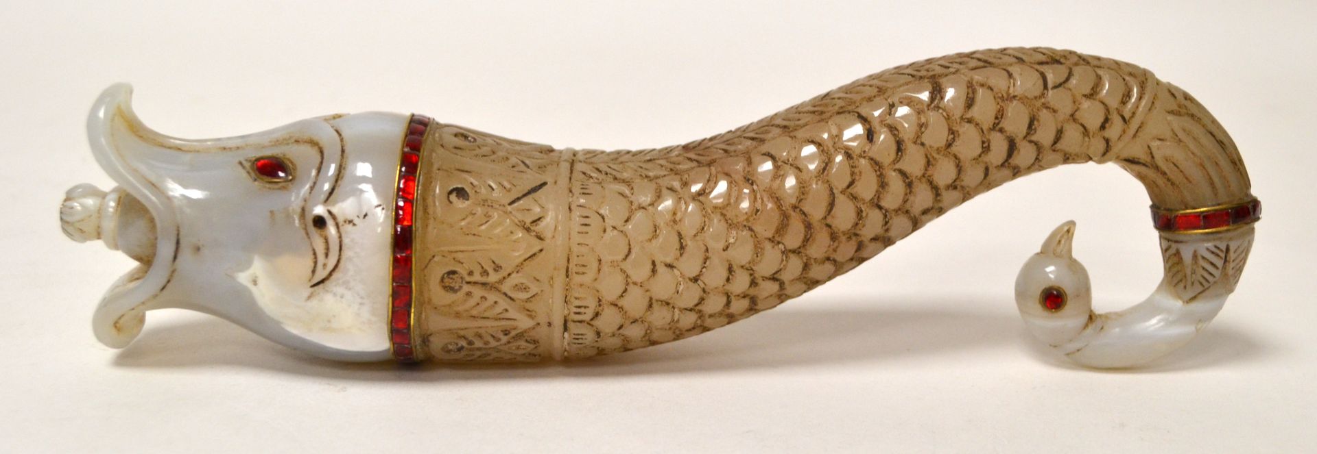 Null 一件用各种色调的玛瑙雕刻成水生动物造型的变形陶罐，头部为马卡拉，尾部为鸟头。壶身雕刻有鳞片和掌纹，球形瓶塞呈莲花花蕾状。印度海得拉巴。长 24 厘米