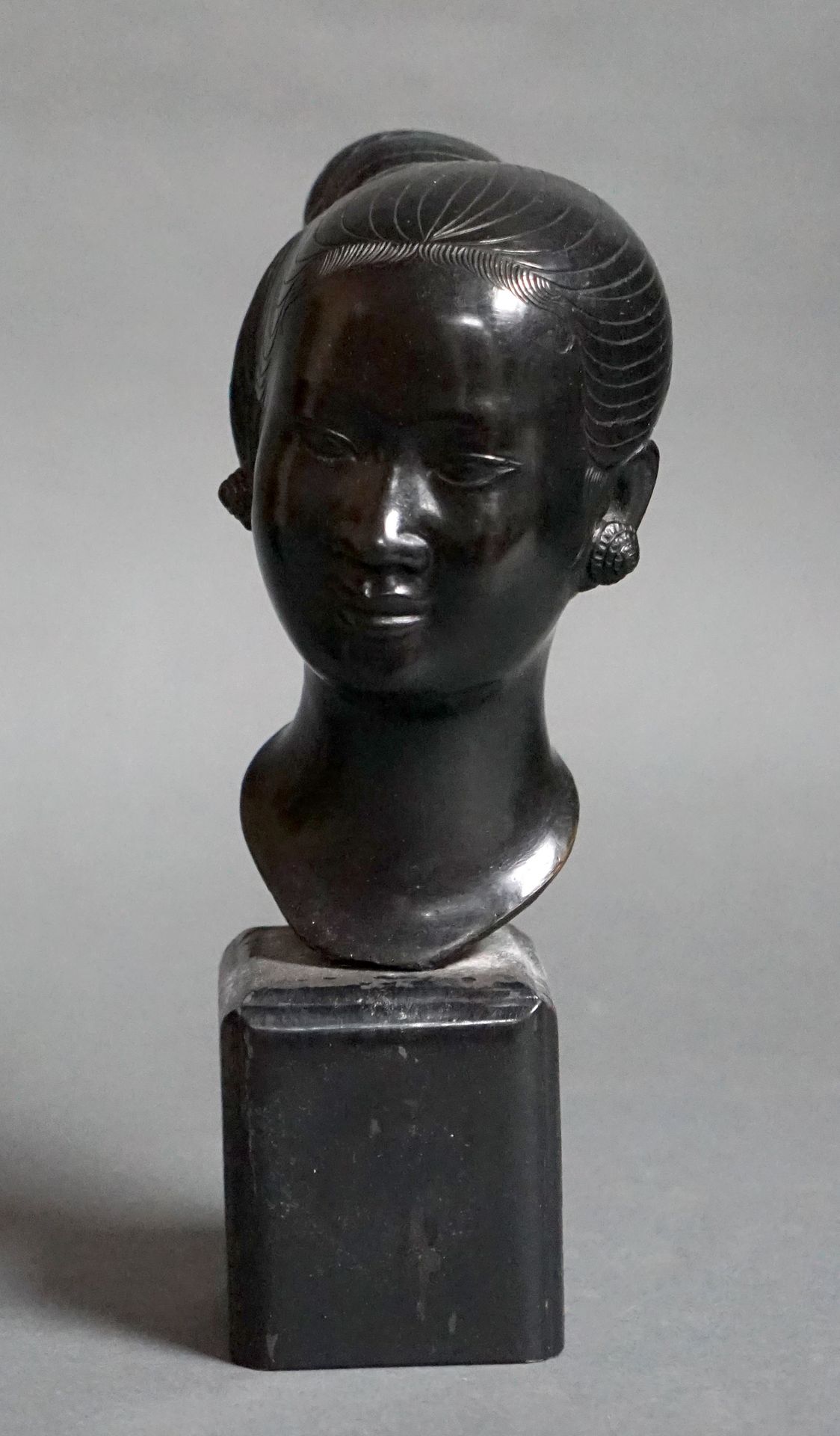Null 20 世纪印度支那流派的老挝妇女半身像。青铜，带黑色铜锈，涂漆木质底座，背面有印记。总高：28 厘米。底座略有缺失。