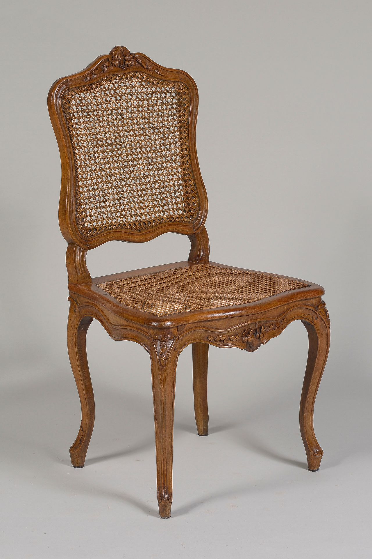 Null Caned chair 

in beech molded and carved with flowers on the back and belt.&hellip;