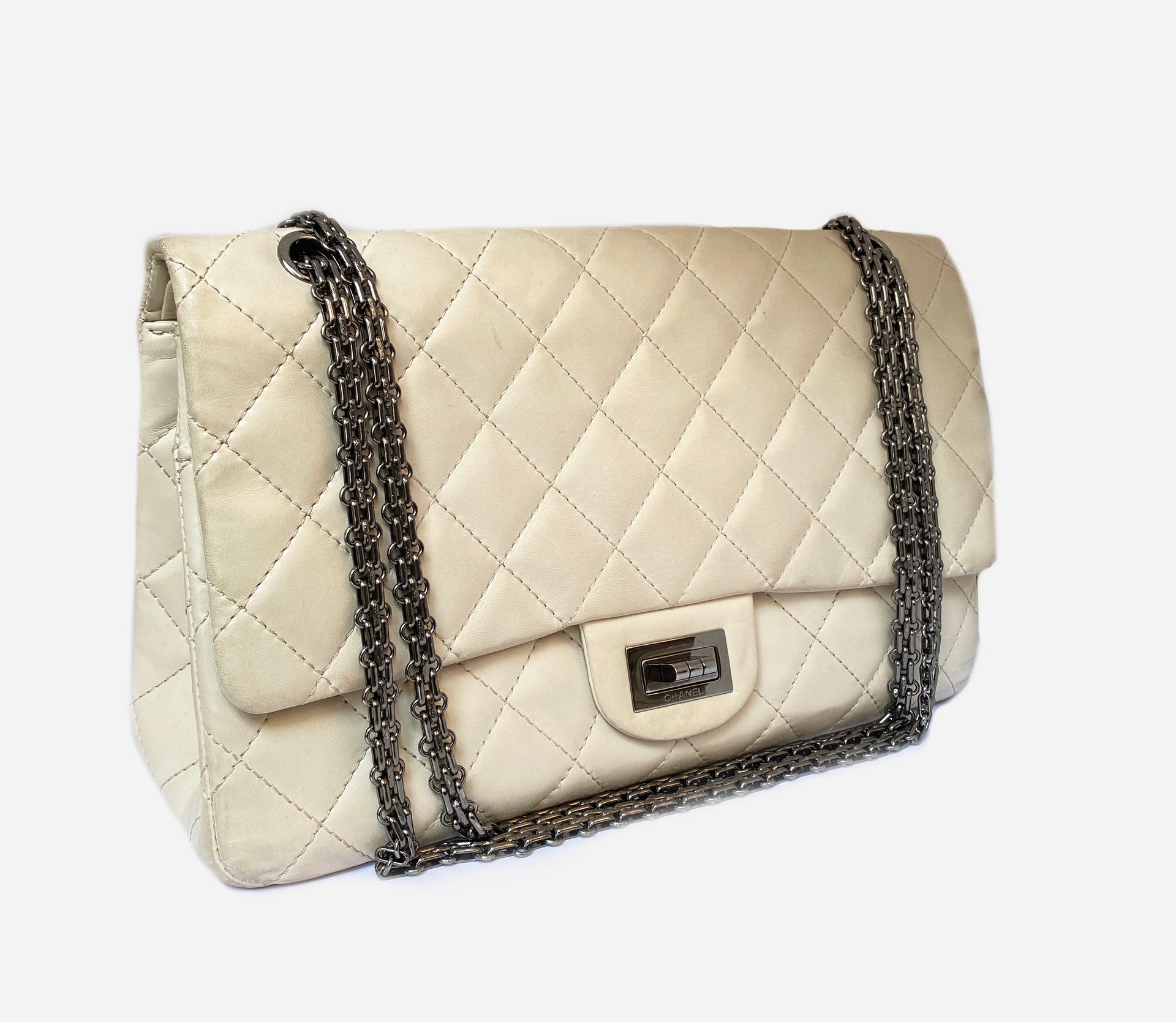 CHANEL. Bag  in ivory lambskin, ruthenium trim. Double flap closure,  Mademoiselle clasp, flat metal chain, sliding for carrying on the shoulder  or across the chest. 31 x 19 cm. Good condition,