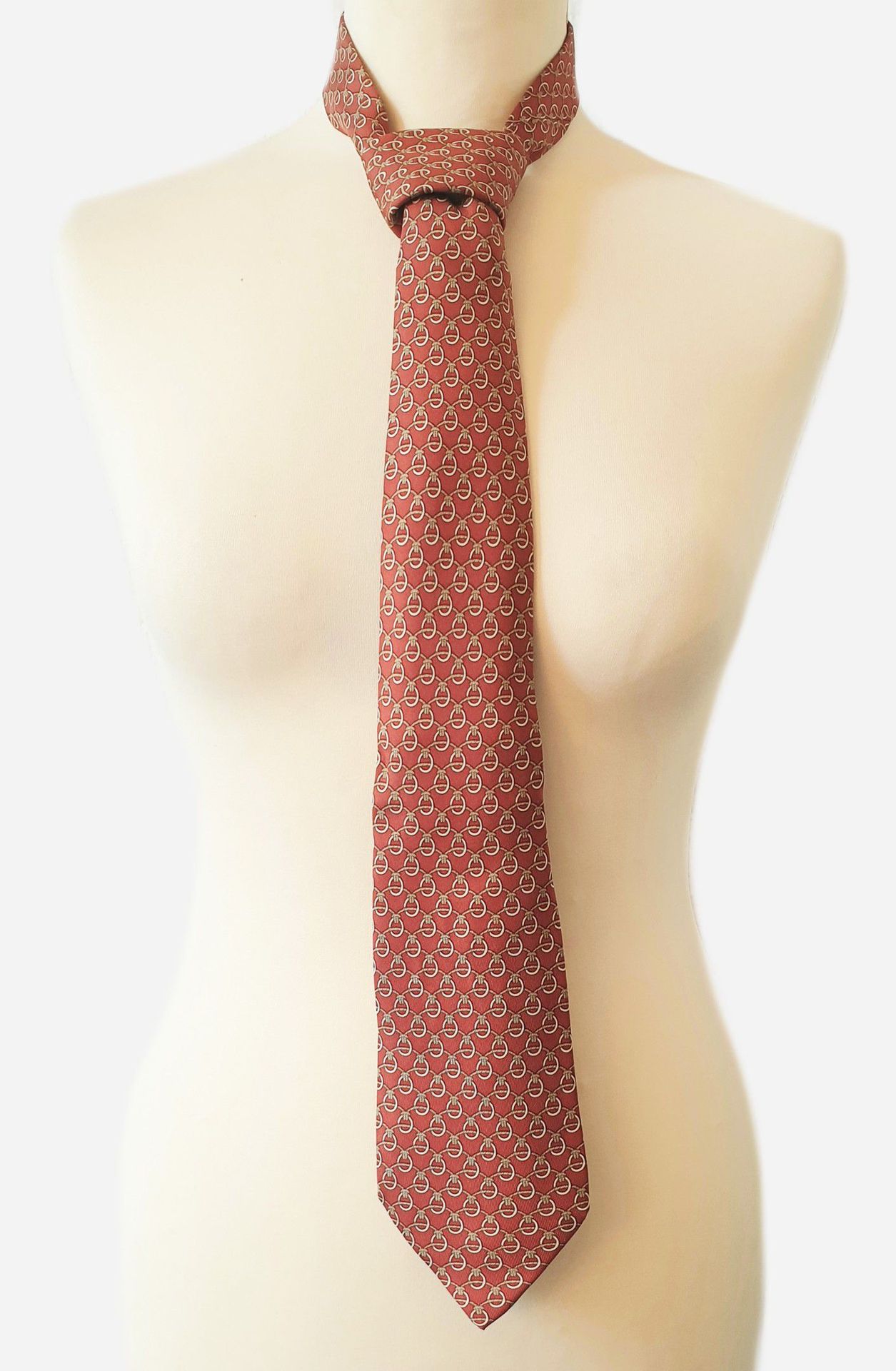 Null 
HERMES. Cravate en soie à fond couleur rouille à motifs de nœuds. Très bel&hellip;