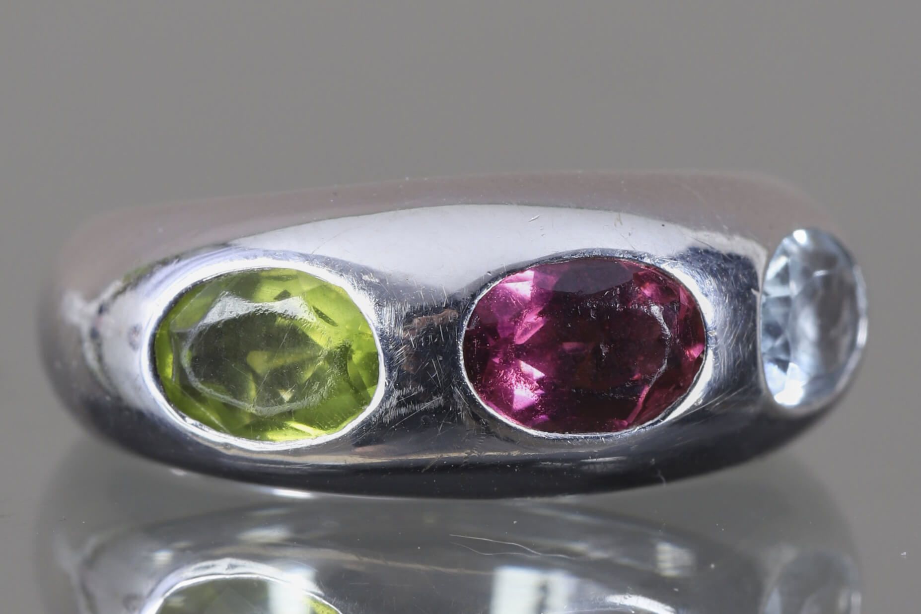 Poiray 美丽的18K(750‰)白金戒指，镶嵌有三个椭圆形彩色宝石（橄榄石、紫水晶和淡蓝色蓝宝石），采用封闭式镶嵌。 
手指大小49 
毛重10.68克