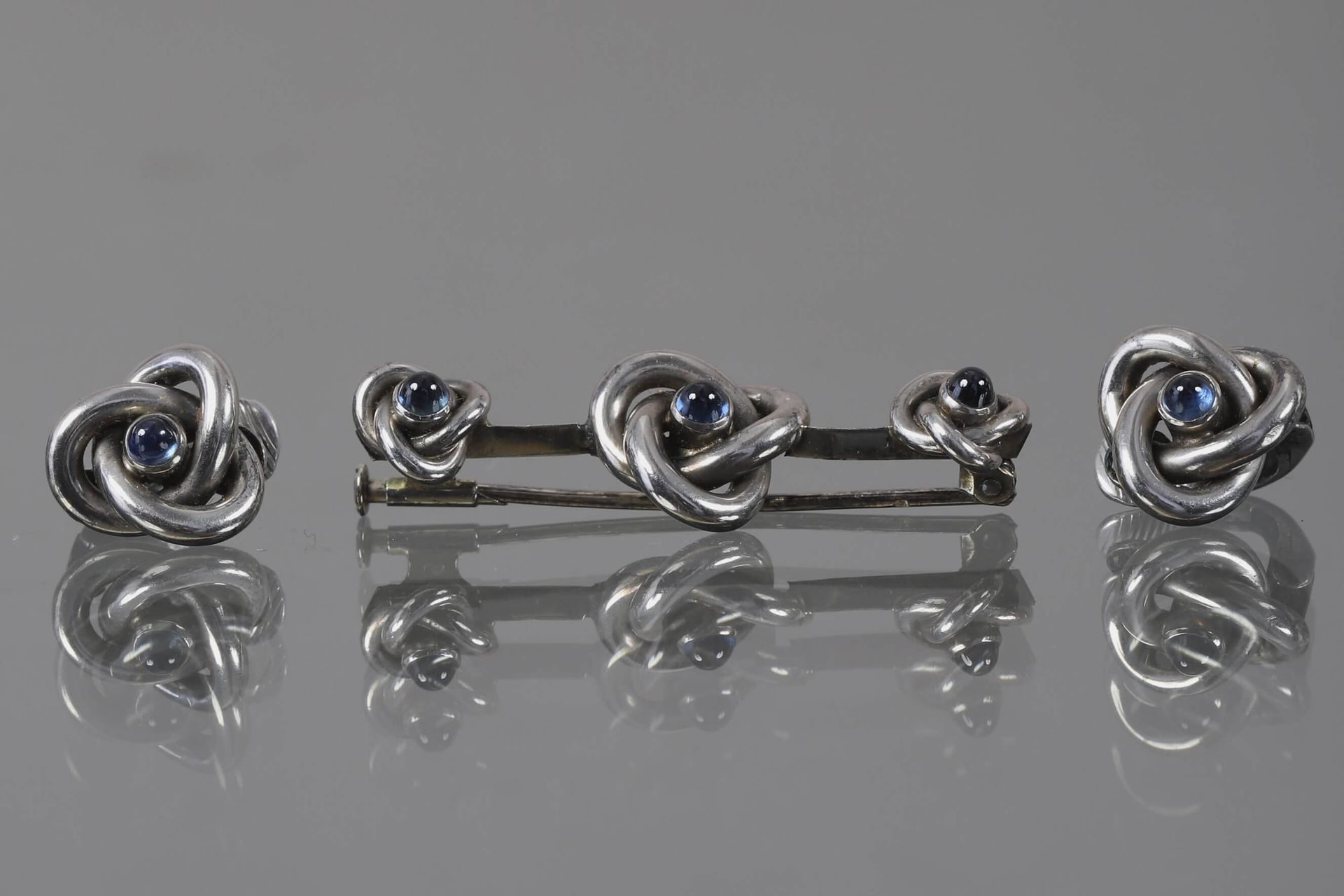 Null 胸针和一对夹子 18K（750‰）白金和凸圆形蓝宝石，夹子附件为银（800‰）。
毛重13克