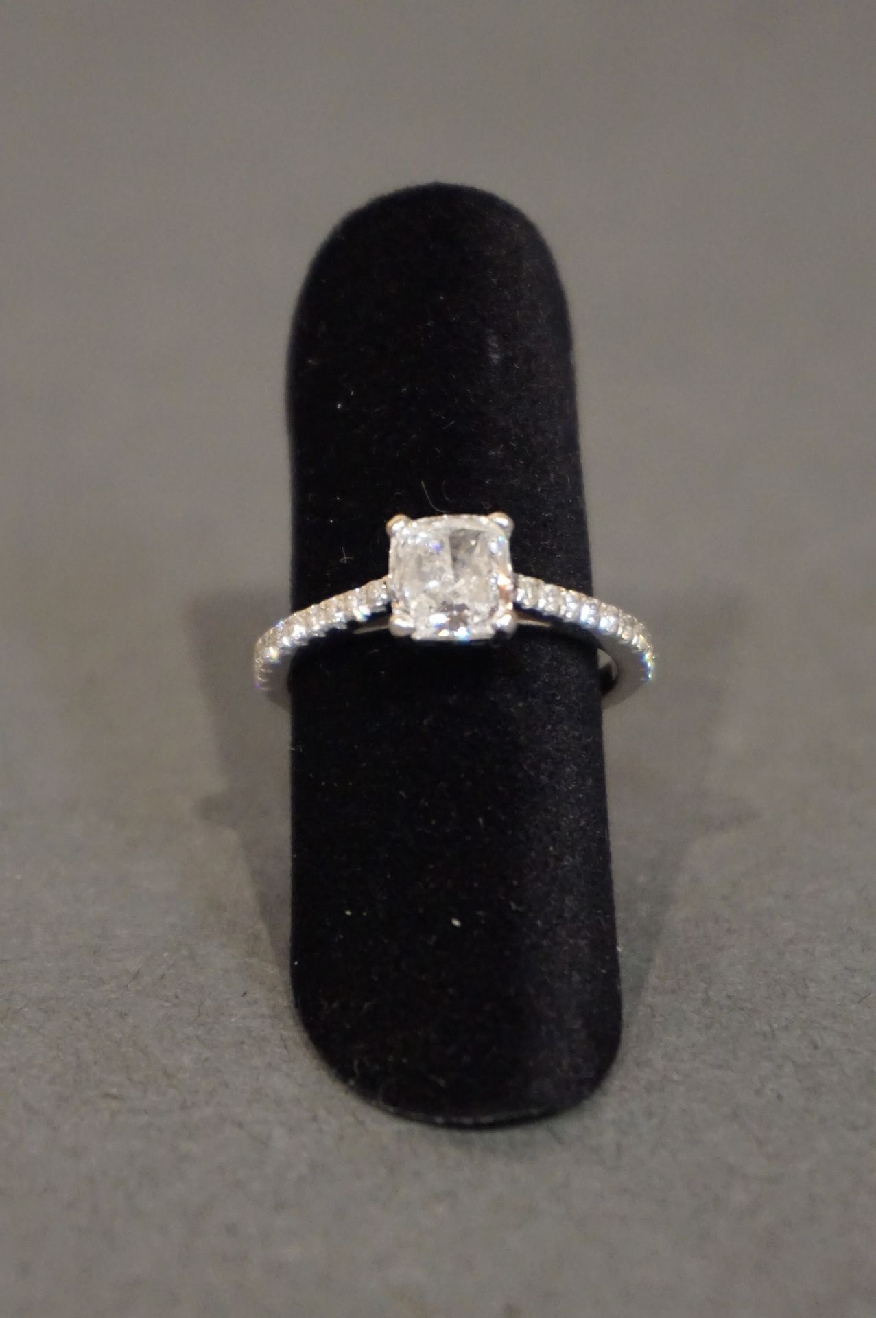 Bague 白金戒指上镶嵌着一颗方形切割的主钻石，圆角，重约0.80至1克拉，两行共20颗小钻石（3克）。手指大小49