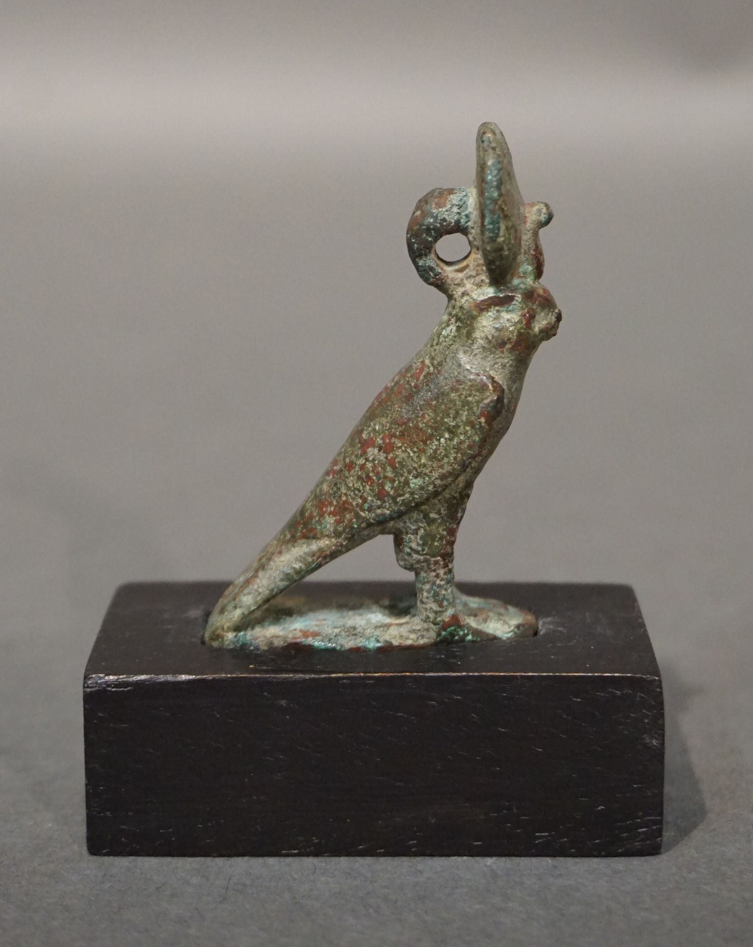 Null 荷鲁斯的雕像，呈猎鹰状。太阳盘背面的悬吊夹。青铜，带有光滑的绿色铜锈。右腿部分缺失。埃及，晚期或托勒密时期，公元前664-32年 高5.6厘米