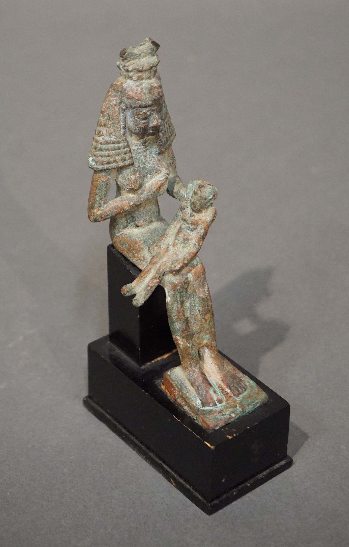 Null 伊希斯-拉克坦斯的雕像。伊希斯的代表是一顶大假发，上面的王冠已经部分消失了。她正抱着她的左胸。哈波克拉底，双臂放在身旁，正坐在他的腿上。青铜，带绿色铜&hellip;