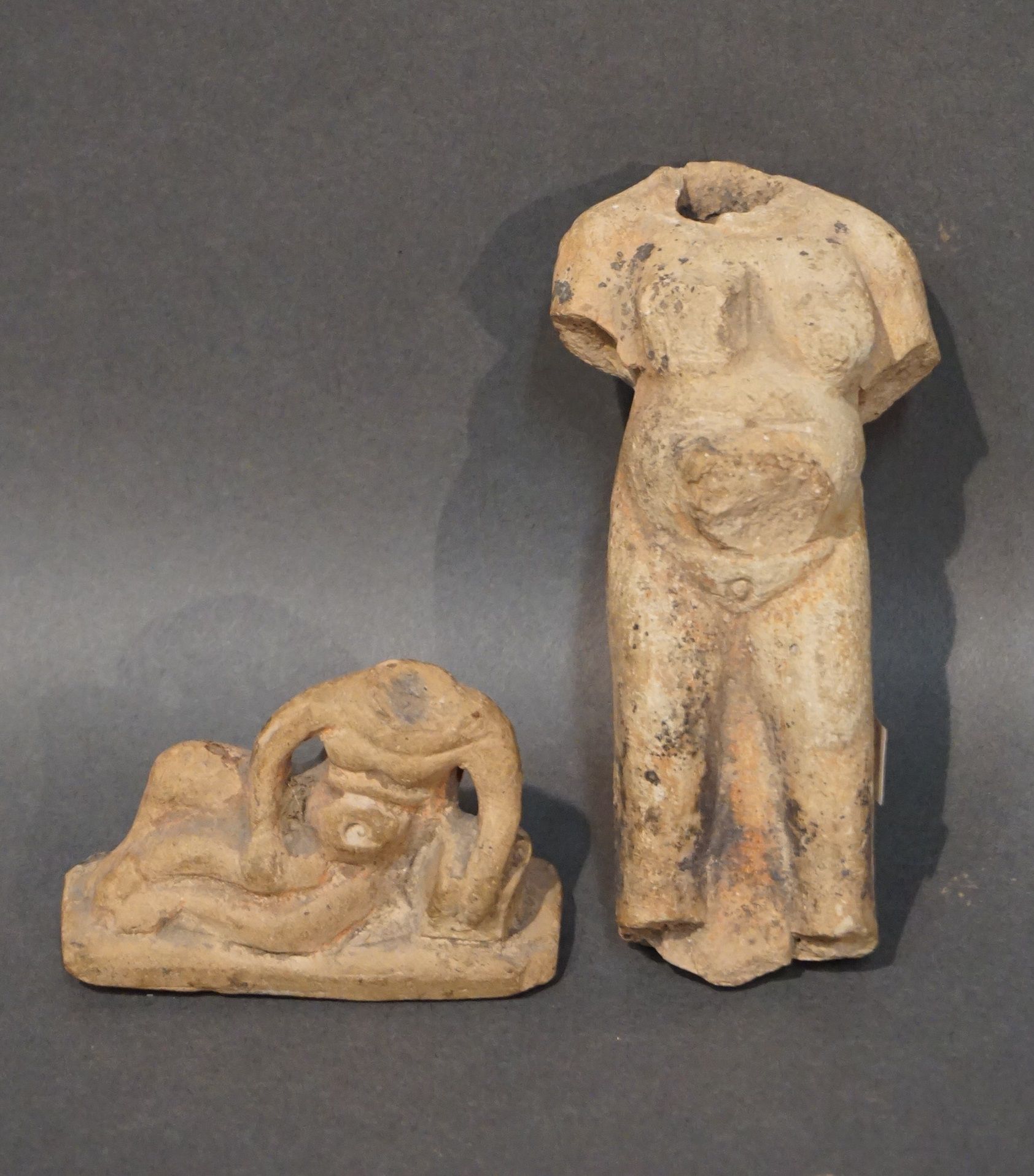 Null 拍卖会上有两件雕像碎片，包括一尊裸体的卧姿、头顶和臀部的雕像和一个怀孕的肥胖裸体女人。米色赤土。缺少和颠簸。埃及，罗马时期。长：13厘米和8厘米