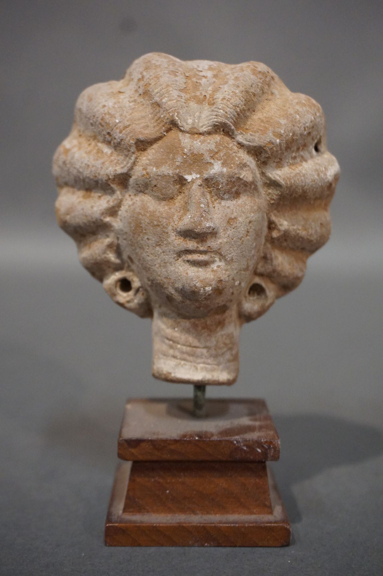 Null 女性头顶上有一个瓜子形的发型，以发髻结束。赭色赤土。埃及，罗马时期，3世纪。高度：9厘米