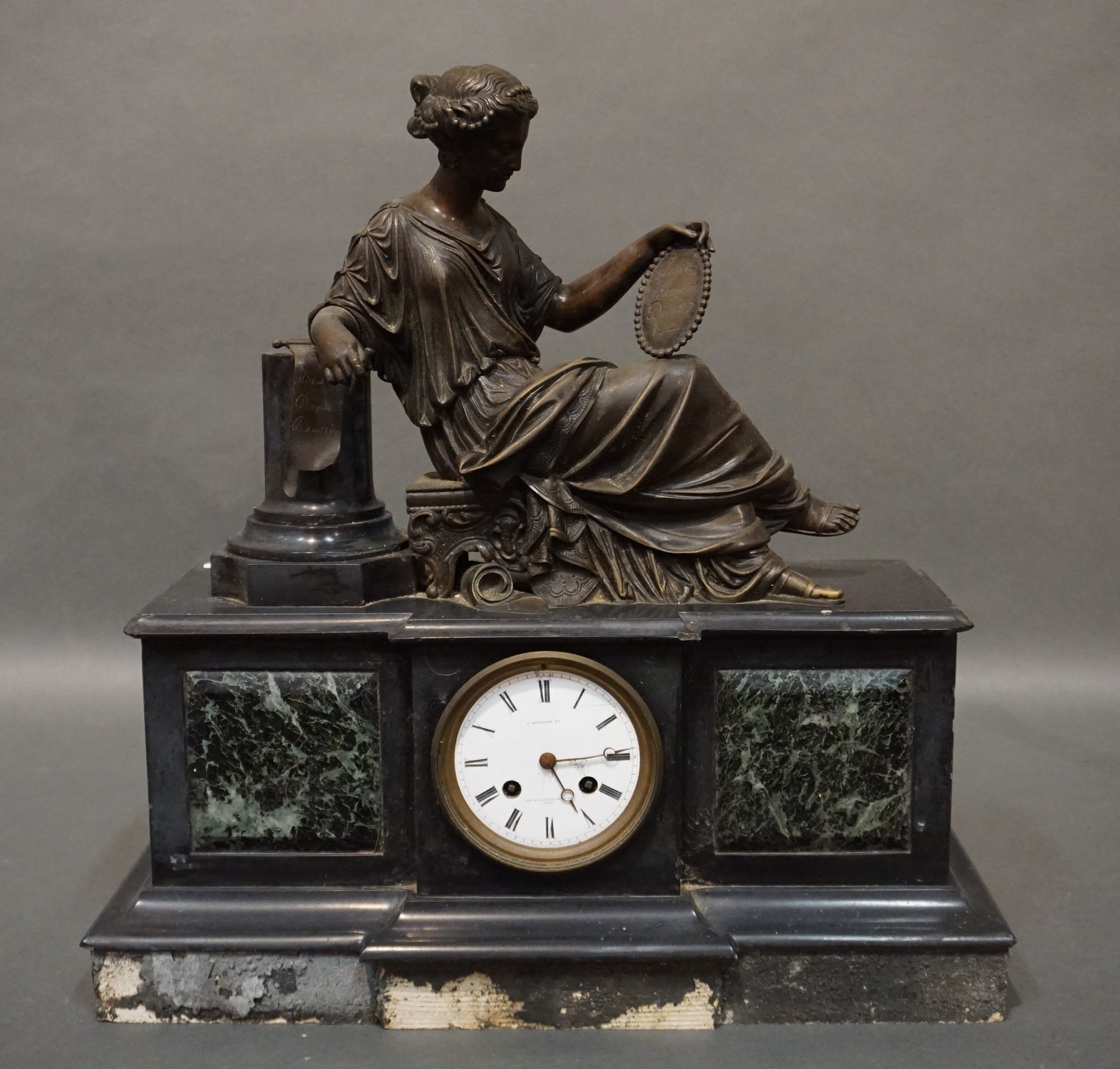 PENDULE Un reloj de mármol negro con una figura de bronce de una mujer apoyada e&hellip;