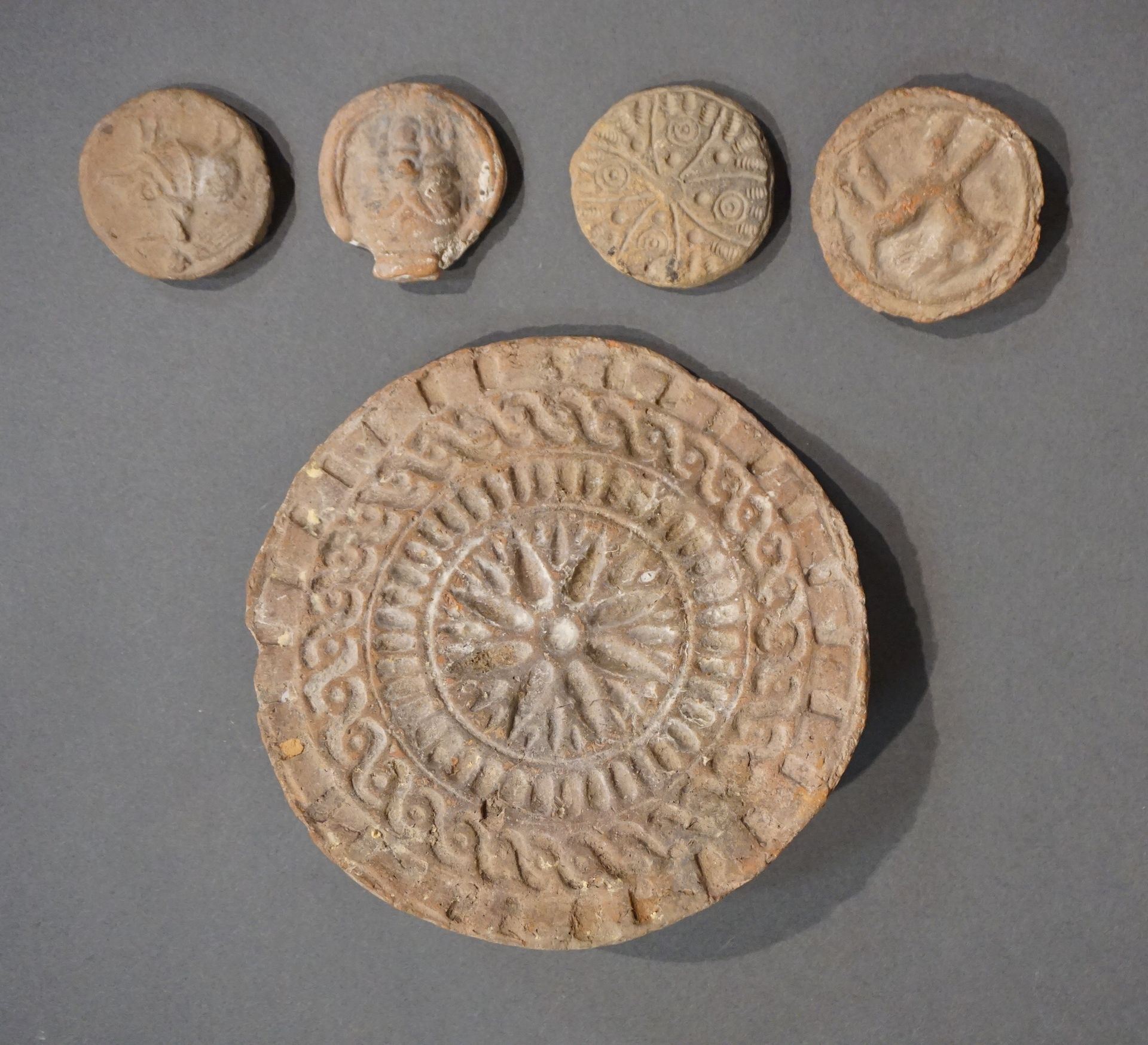 Null 拍品包括一个面包模子，一个浮雕的贝斯头像，一个带帽檐的圆盘和一个带十字架装饰的圆盘，以及一个代表厄洛斯在母猪身上的圆盘。常见的赭石色赤土。罗马时期。直&hellip;