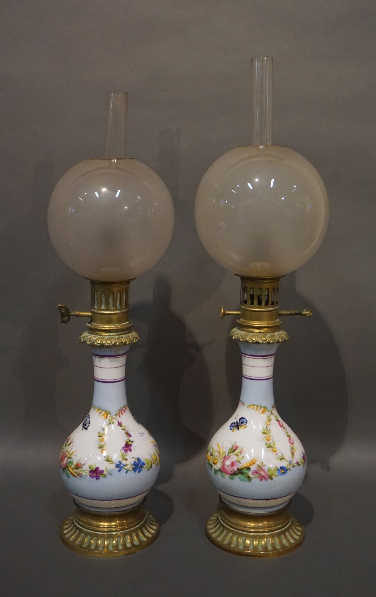 Null Pair of porcelain oil lamps decorated with butterflies and flowers, on a bl&hellip;