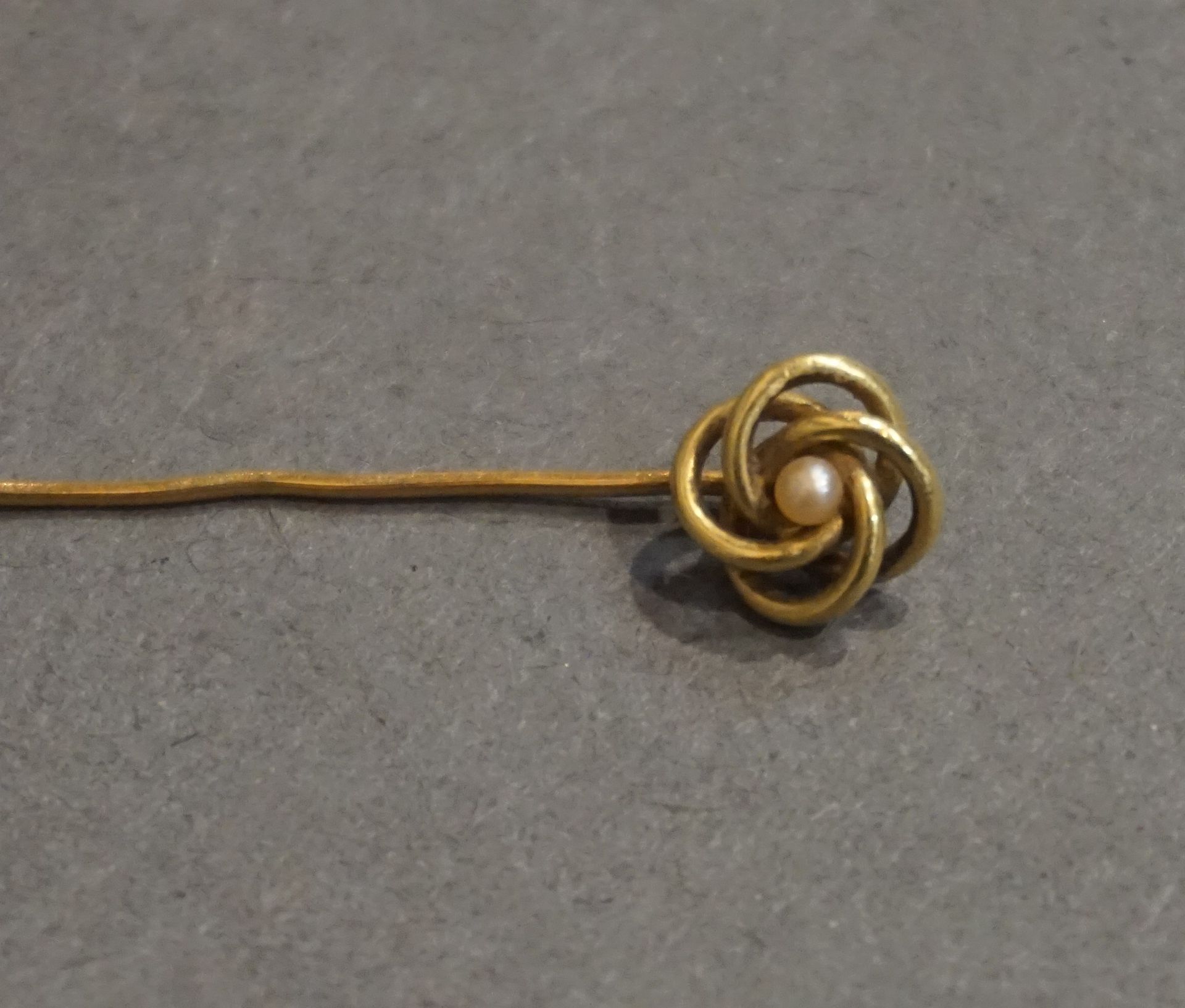Epingle Goldene Anstecknadel mit Wickelmotiv, besetzt mit einer Perle (1 gr)