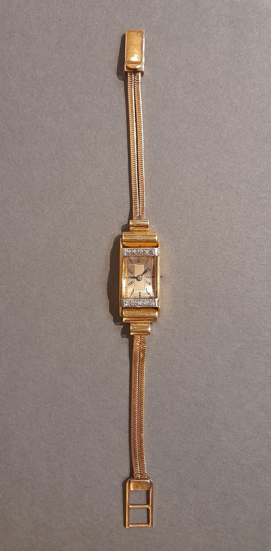 Montre 黄金和铂金女式腕表，长方形表盘由两行五颗小钻石构成。缺少上链装置（盒子毛重33克）。