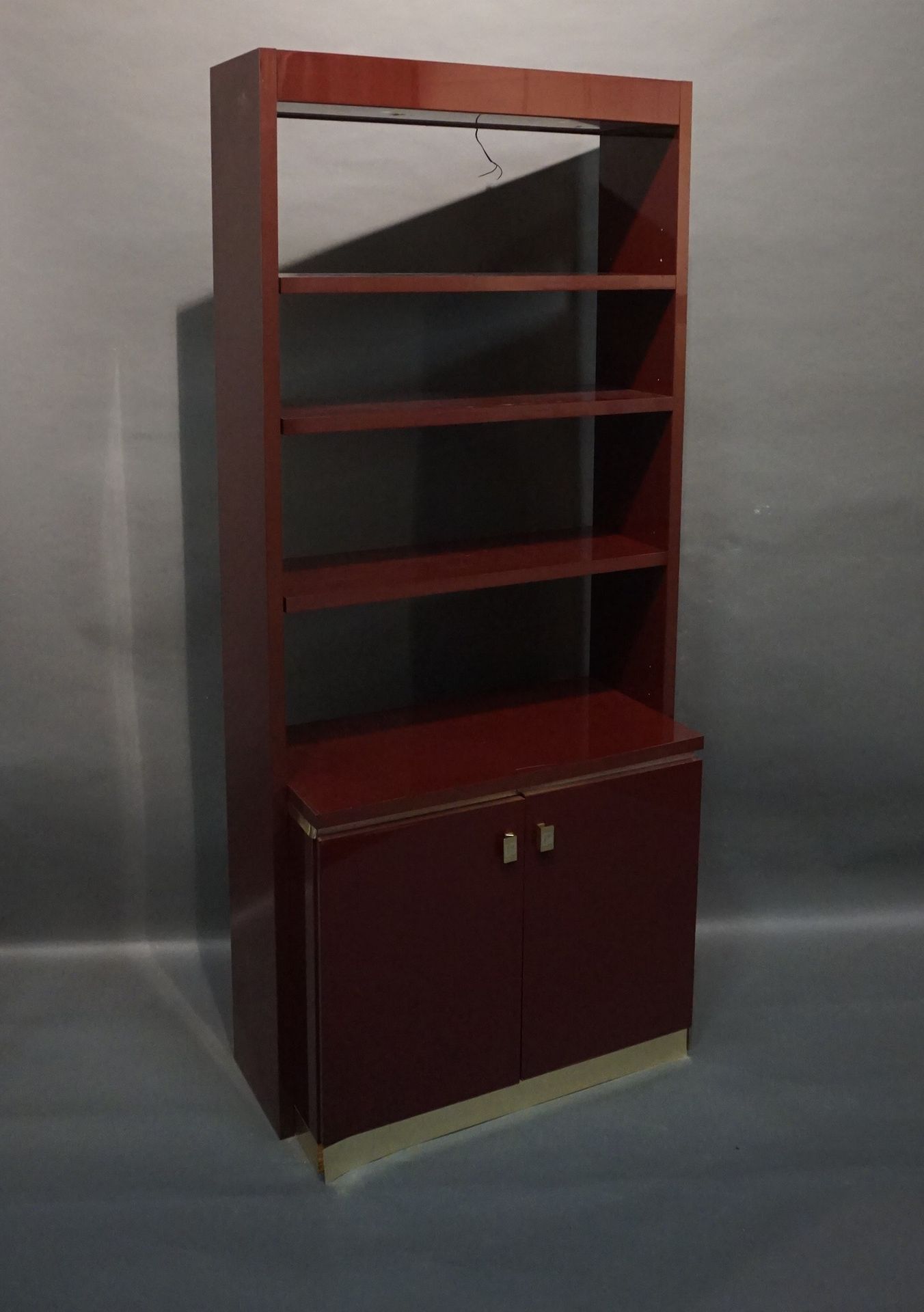 Paco RABANNE (1934-2023) 带两扇下门的酒红色漆木书柜，镀金条和黄铜把手。印有 "PR "字样（带电，有划痕和脱落）。210x93.5x4&hellip;