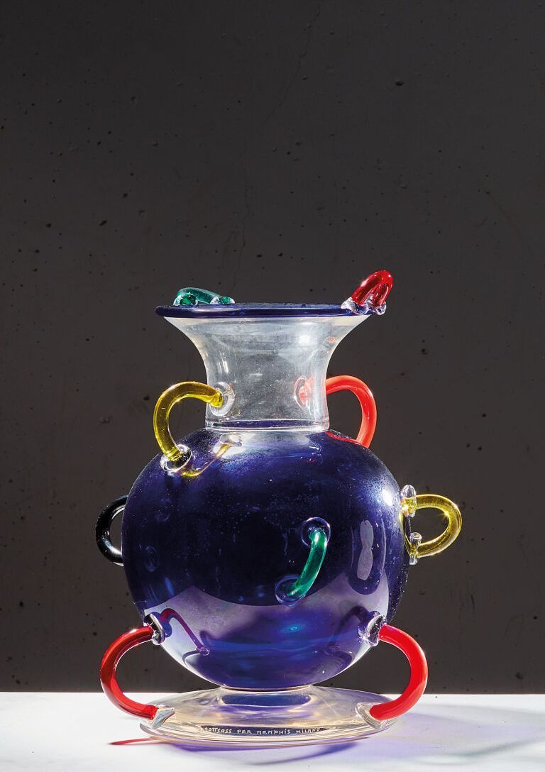 Null 埃托里-索塔斯（1917-2007）。
米扎尔花瓶-模型设计于1982年。
蓝色和透明玻璃，多色手柄。
孟菲斯米兰版。
高_32厘米，长_30厘米。
&hellip;
