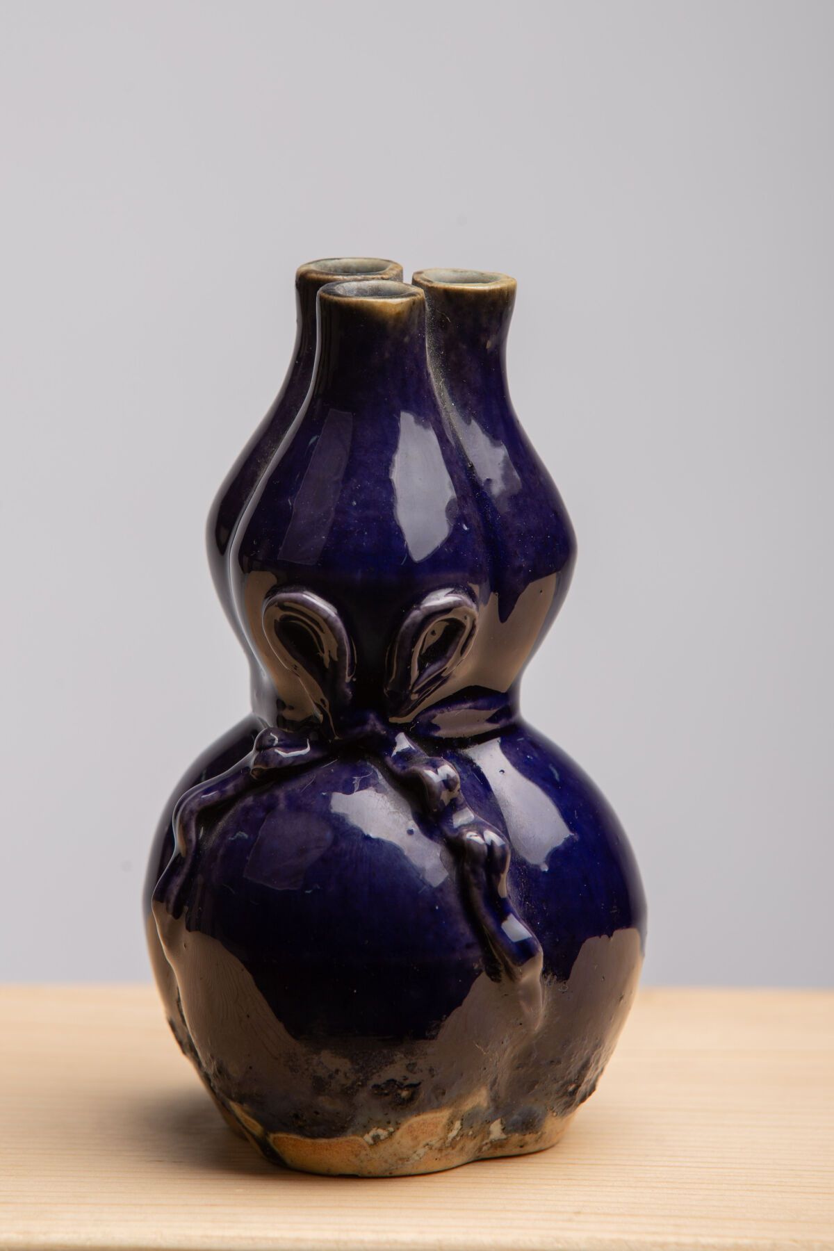 Null 中国。 
一个午夜蓝釉石器三层葫芦花瓶，装饰有打结的丝带。 
高11.5厘米