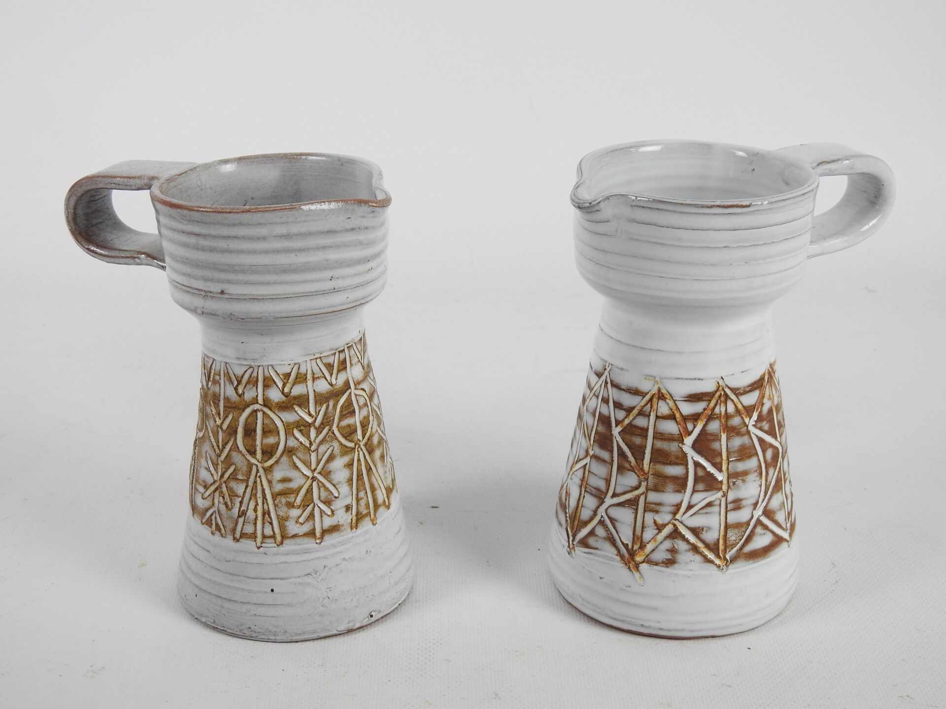 Null LES ARGONAUTES（瓦洛里）。一对陶瓷壶，奶油色背景上有棕色的几何装饰。背面有签名。高：17厘米。