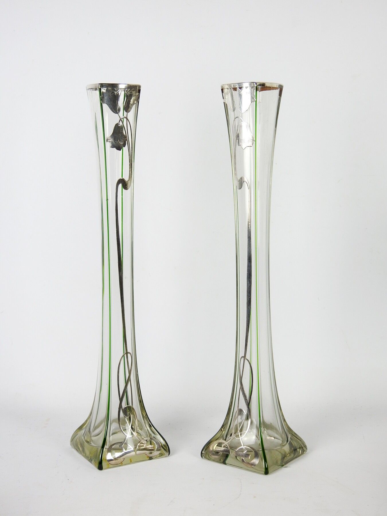 Null 新艺术。一对高半透明的吹制玻璃Soliflores花瓶，角上涂有绿色的线条。银色框架，带花纹装饰。1900年左右，德国或波西米亚。高：51厘米