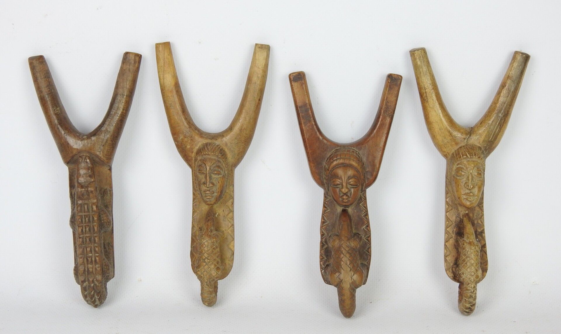 Null 鲍勒人，象牙海岸。

木头，有轻微的铜锈。

一套四把弹弓，雕刻着女性面孔，穿山甲和鳄鱼。

长度：17.5厘米-18.5厘米-19厘米。