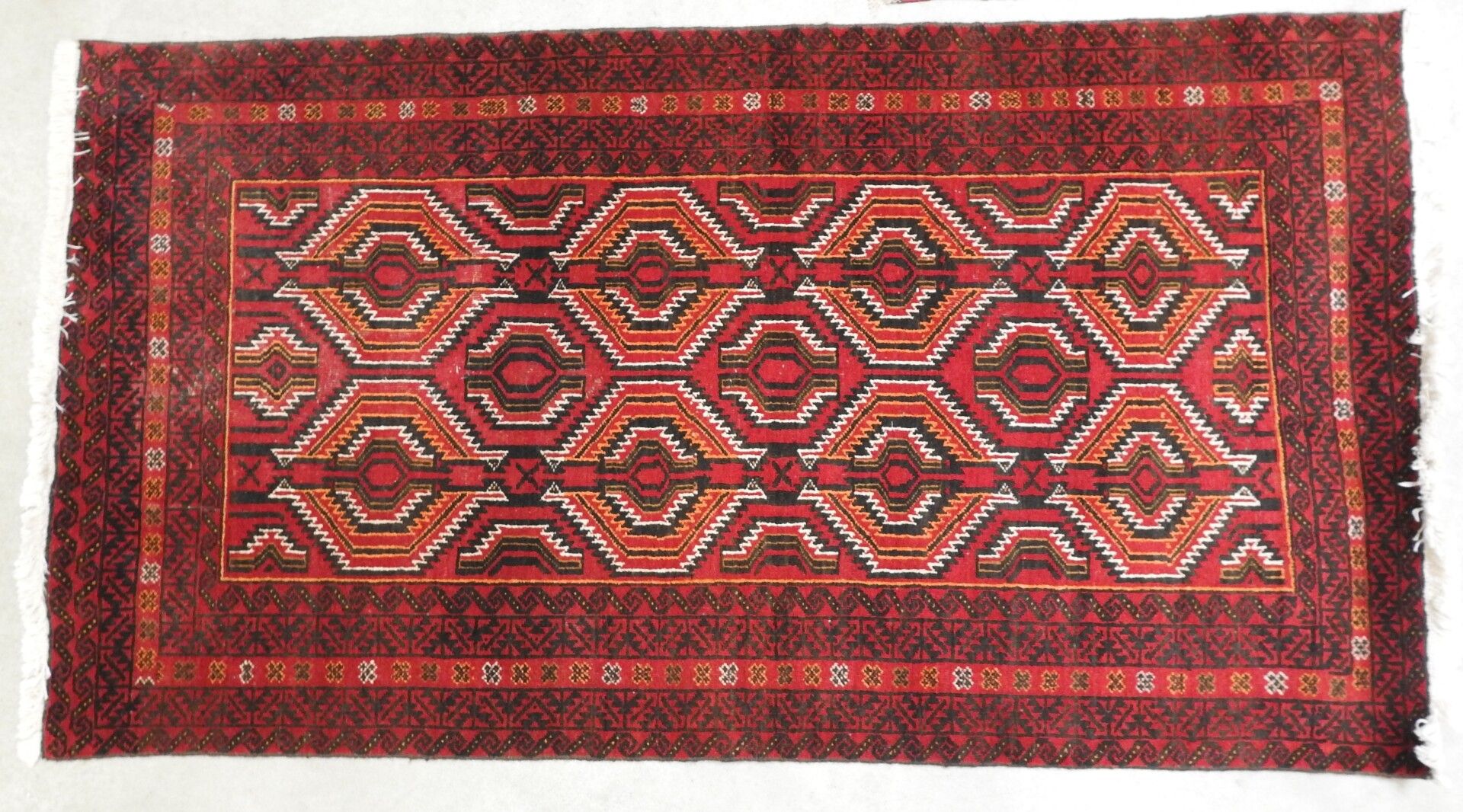 Null CAUCASE : Tapis en laine à fond rouge. 107 x 193 cm.