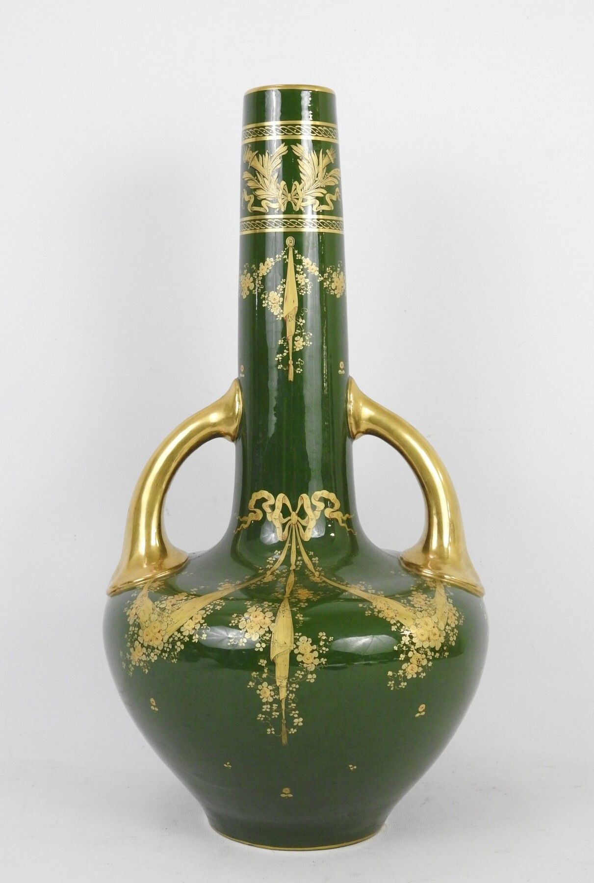 Null 旅游：一个装饰着鲜花、丝带、帷幔和金色火炬的瓷质长颈瓶。镀金的手柄。高度：57厘米。