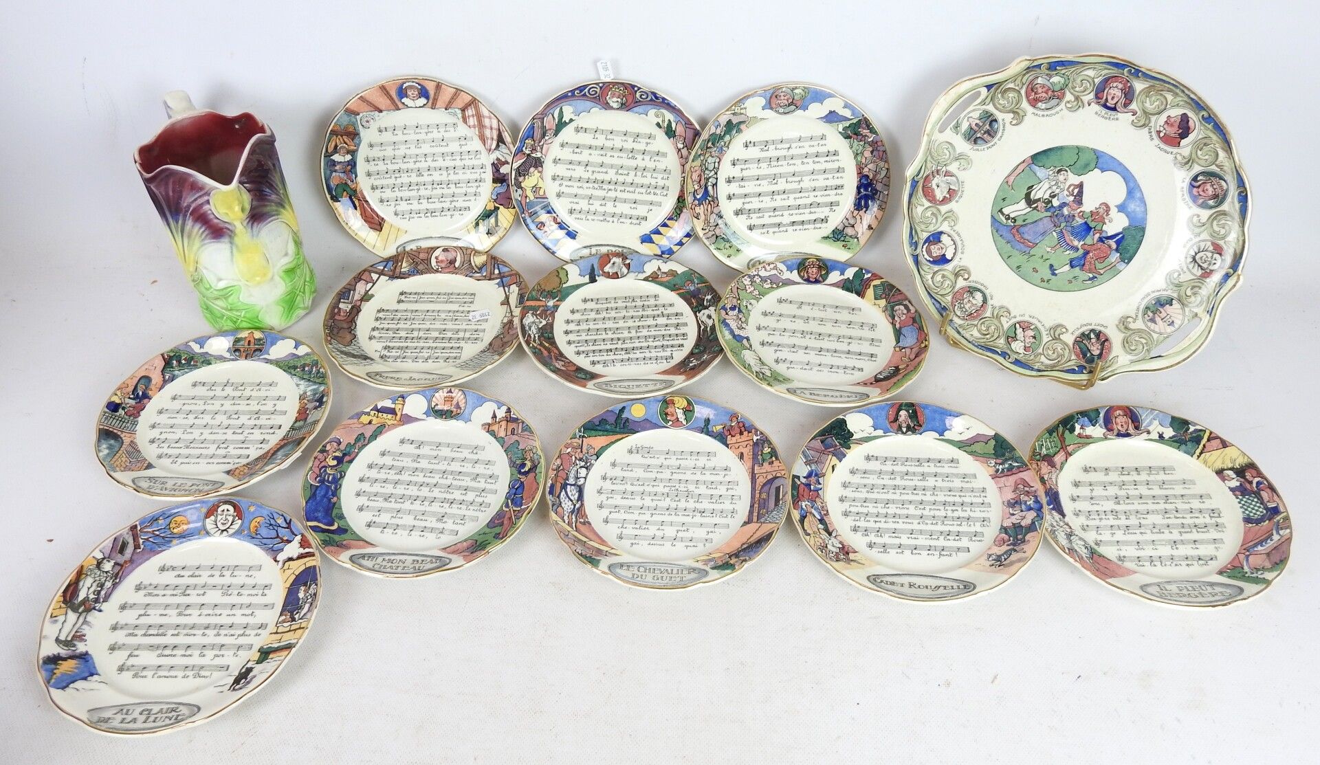 Null SARREGUEMINES：12个盘子和一个盘子，用陶器装饰，上面有法国的歌曲和圆盘。附上一个来自ONNAING的巴比伦的投手。高度：20厘米。