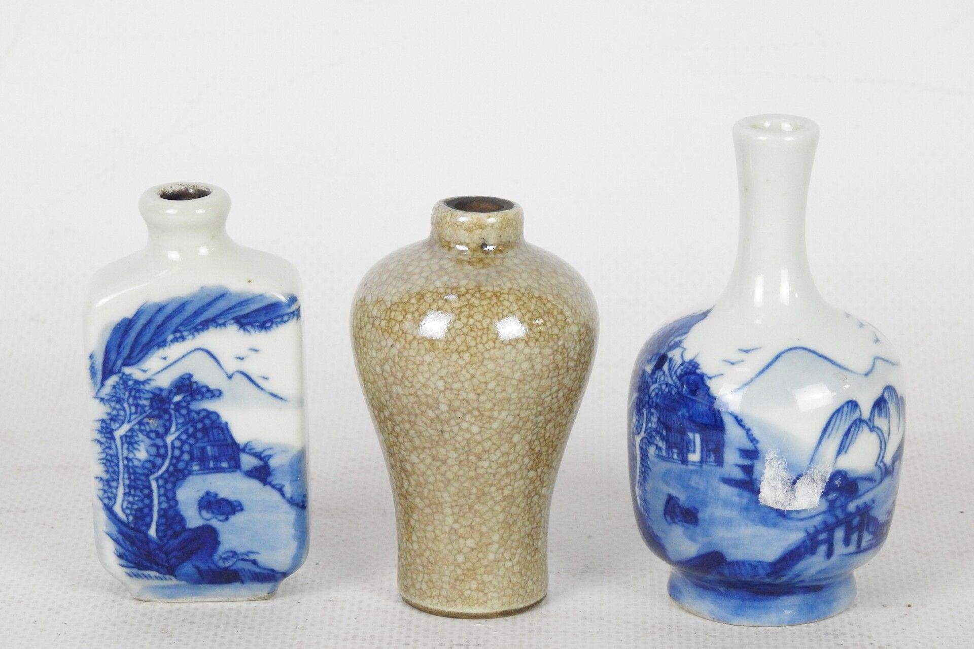 Null 中国: 一件包括山水纹小长颈瓷瓶，背面有蓝叶纹，高：7厘米，山水纹瓷鼻烟壶，背面有蓝叶纹，高：6.5厘米。缺少塞子和有裂缝的小陶瓶。高度：6厘米。