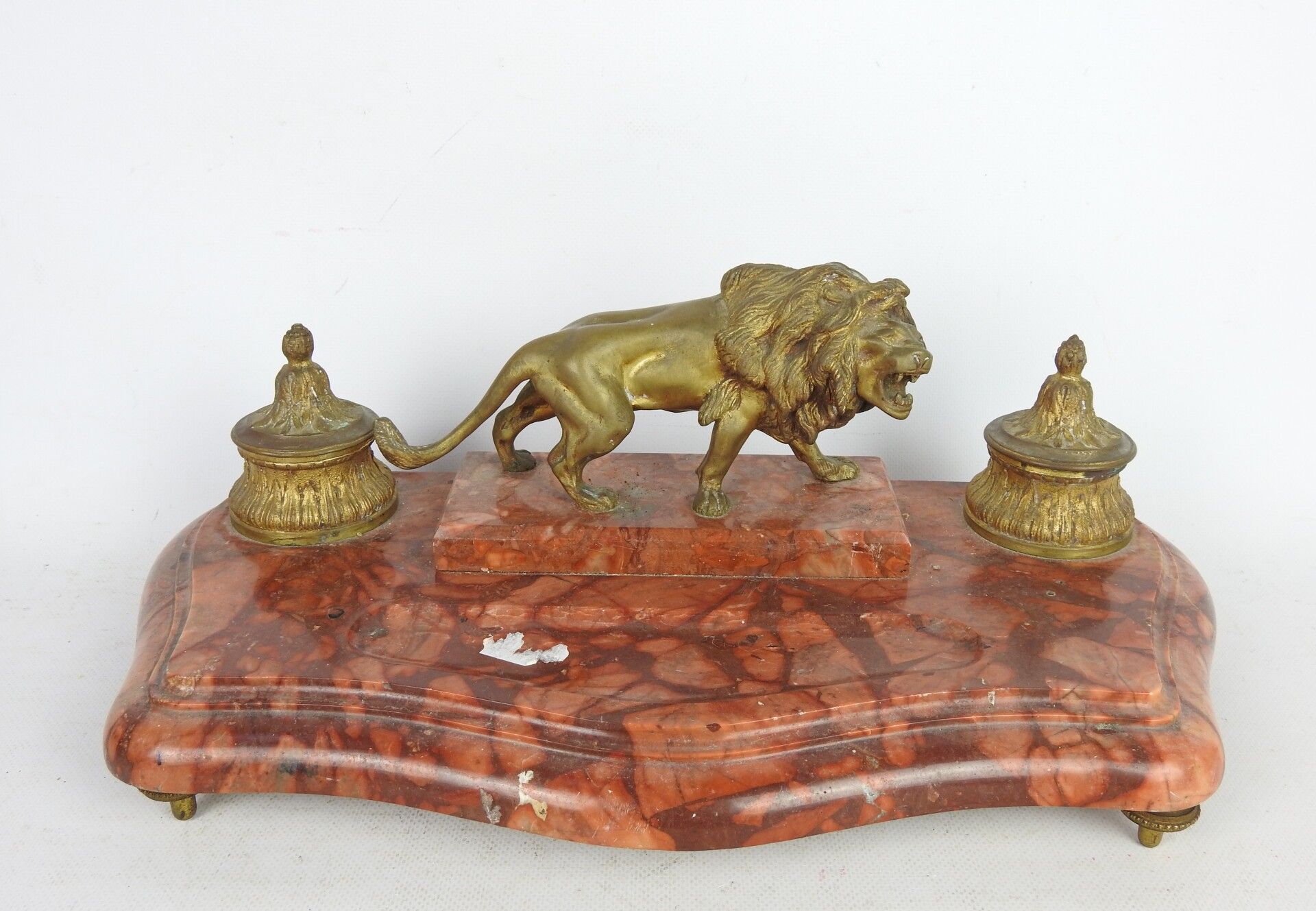 Null 一张红色大理石书桌，上面有一只兽皮狮子和两个坦克。旋转的顶腿。 19世纪晚期。18 x 44 x 23厘米。