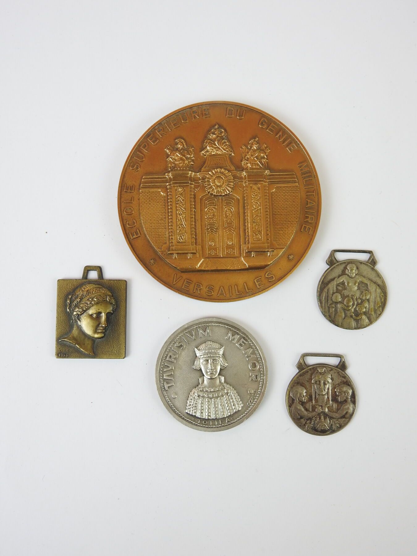 Ein Set aus fünf Medaillen, darunter eine große Bronzeme…