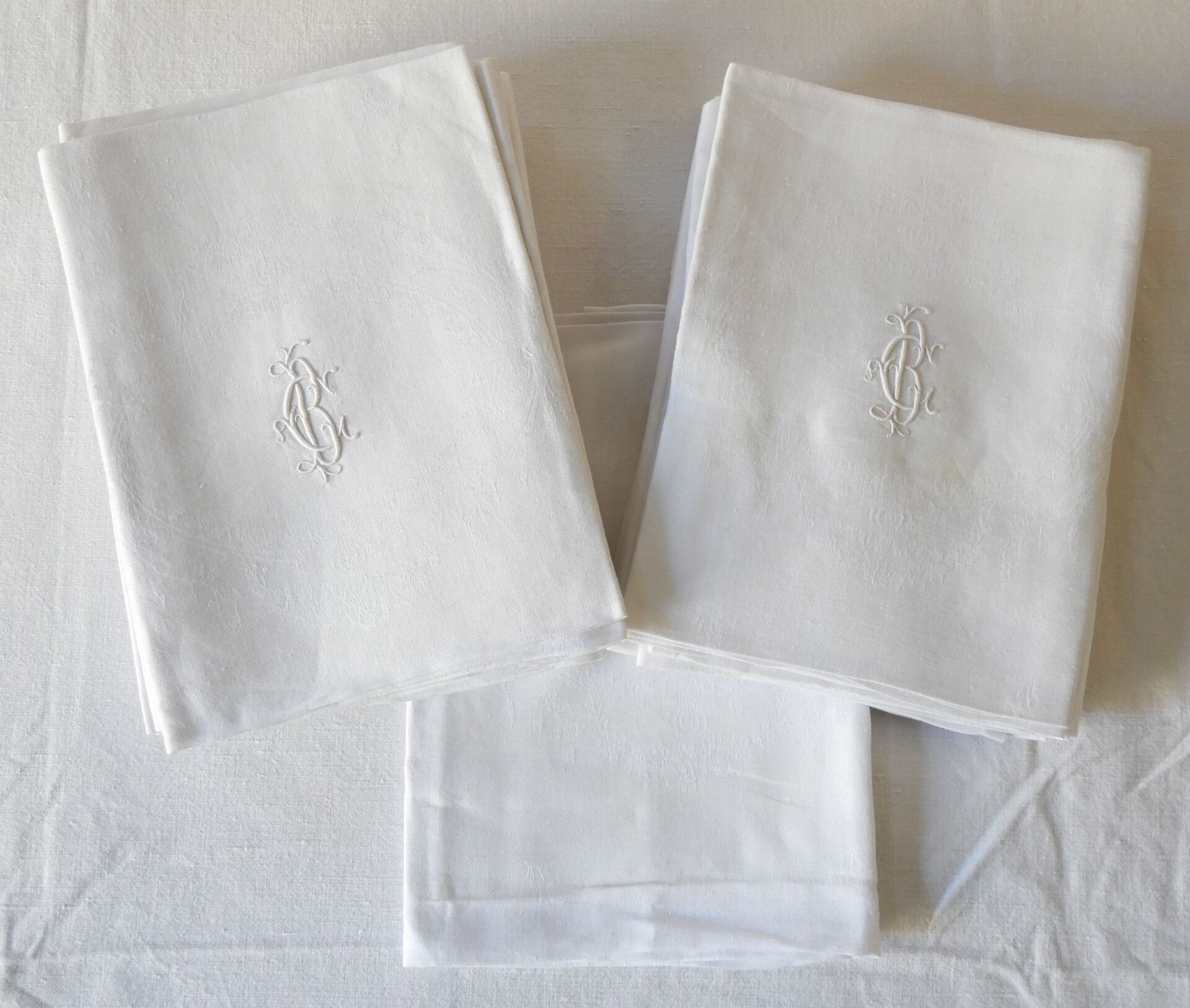 Null 十八张大马士革餐巾纸，上面有花朵和中央的奖章，编号为C.B。