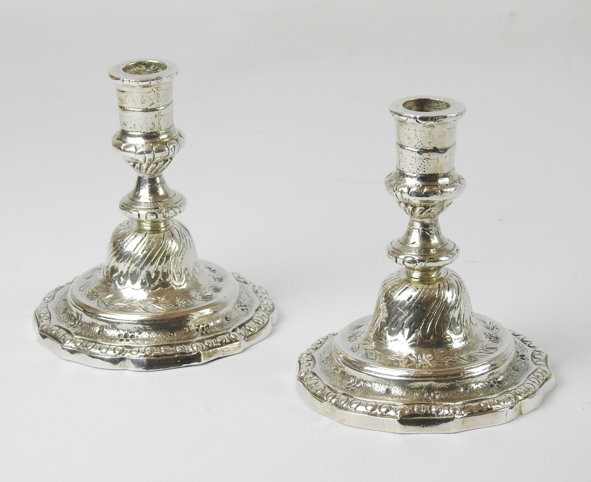 Null 一对镀银的铜质办公桌烛台，脚上装饰着橄榄树和羊角花，花和月桂树叶。路易十六时期。高13厘米。