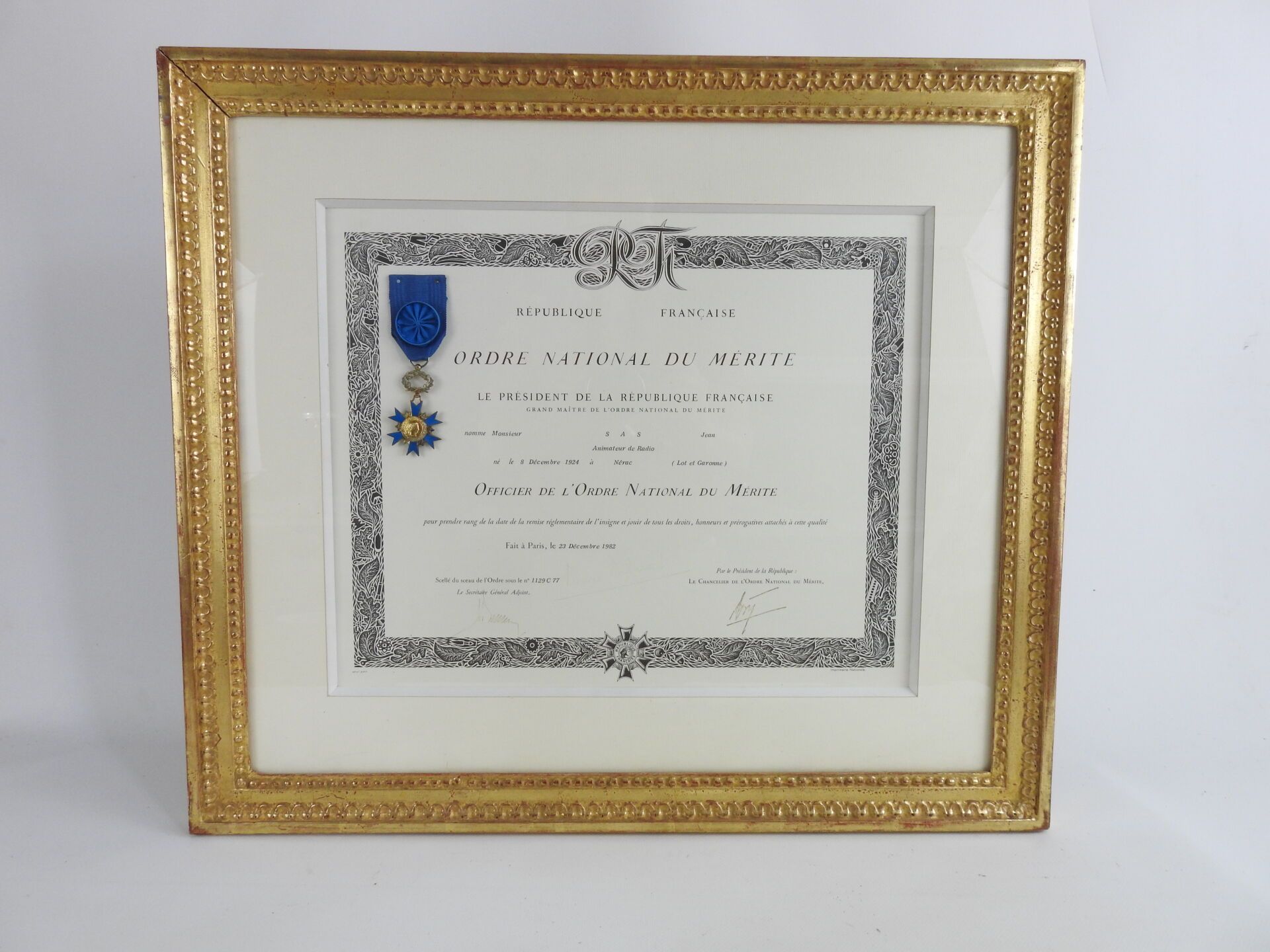 Null 装饰品。法国。 国家荣誉勋章的军官十字勋章和它的证书，装在一个漂亮的玻璃框架下，有珍珠木杆，归功于幽默大师Jean SAS，1982年。TBE SAS&hellip;