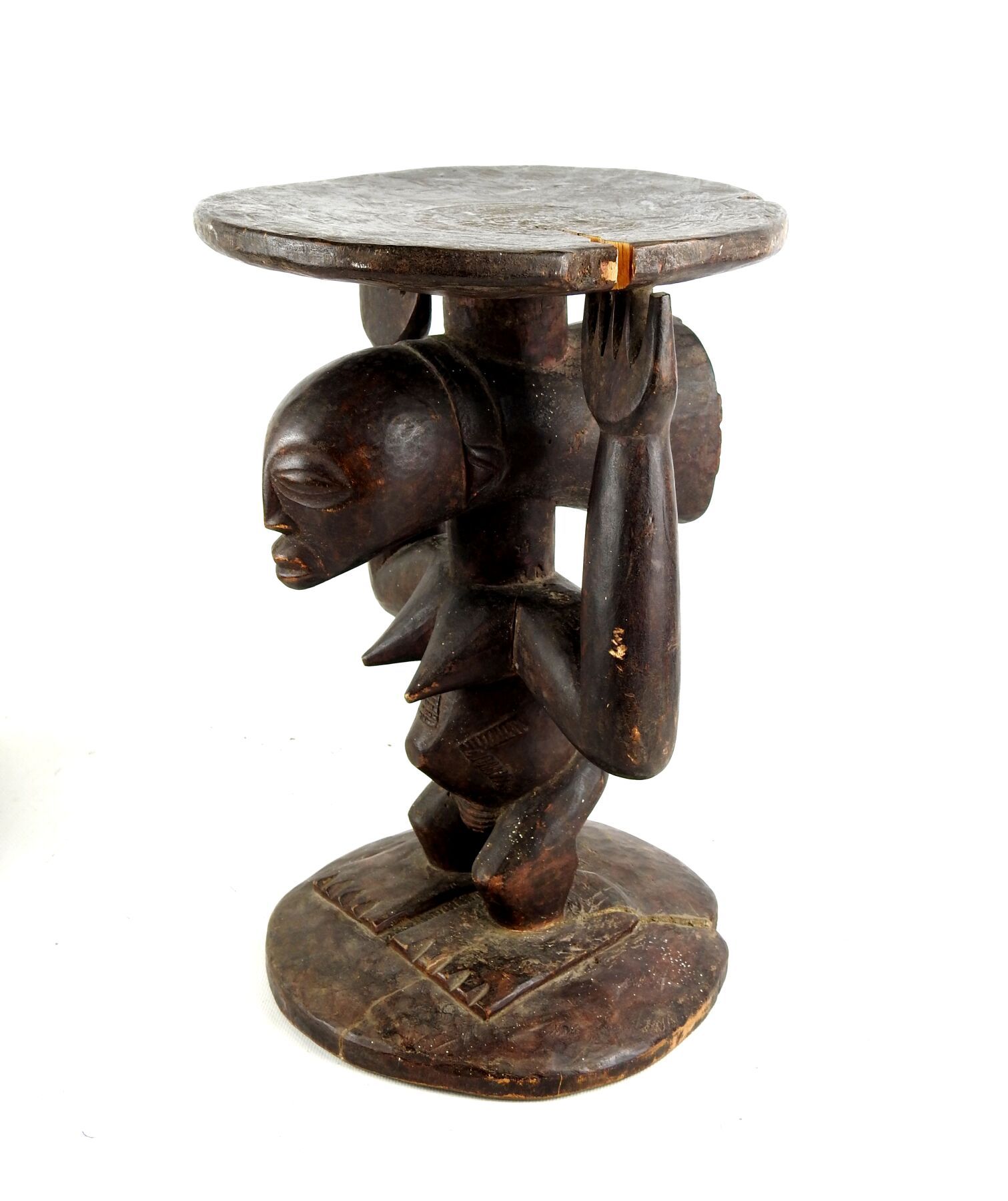Null LUBA，刚果民主共和国。
硬木，棕色铜锈。
座椅上有代表站立人物的卡利亚特，站立的手臂象征性地支撑着座椅。
高度：36厘米。
小事故和缺失的零件。