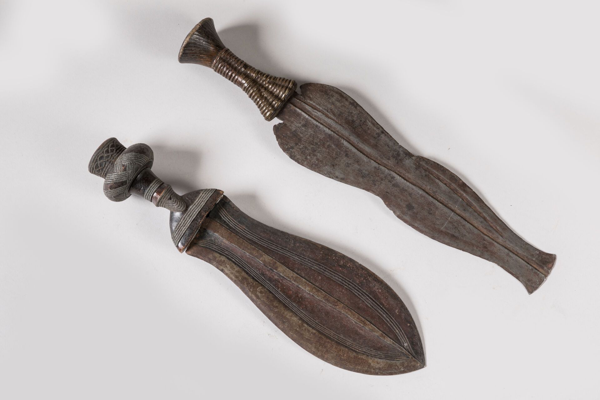 Null KUBA和NGALA，刚果民主共和国。
木头，铁，有使用痕迹的，黄铜。
一把 "伊库尔 "匕首和一块切片的重合。
长度：35厘米和38.5厘米。
