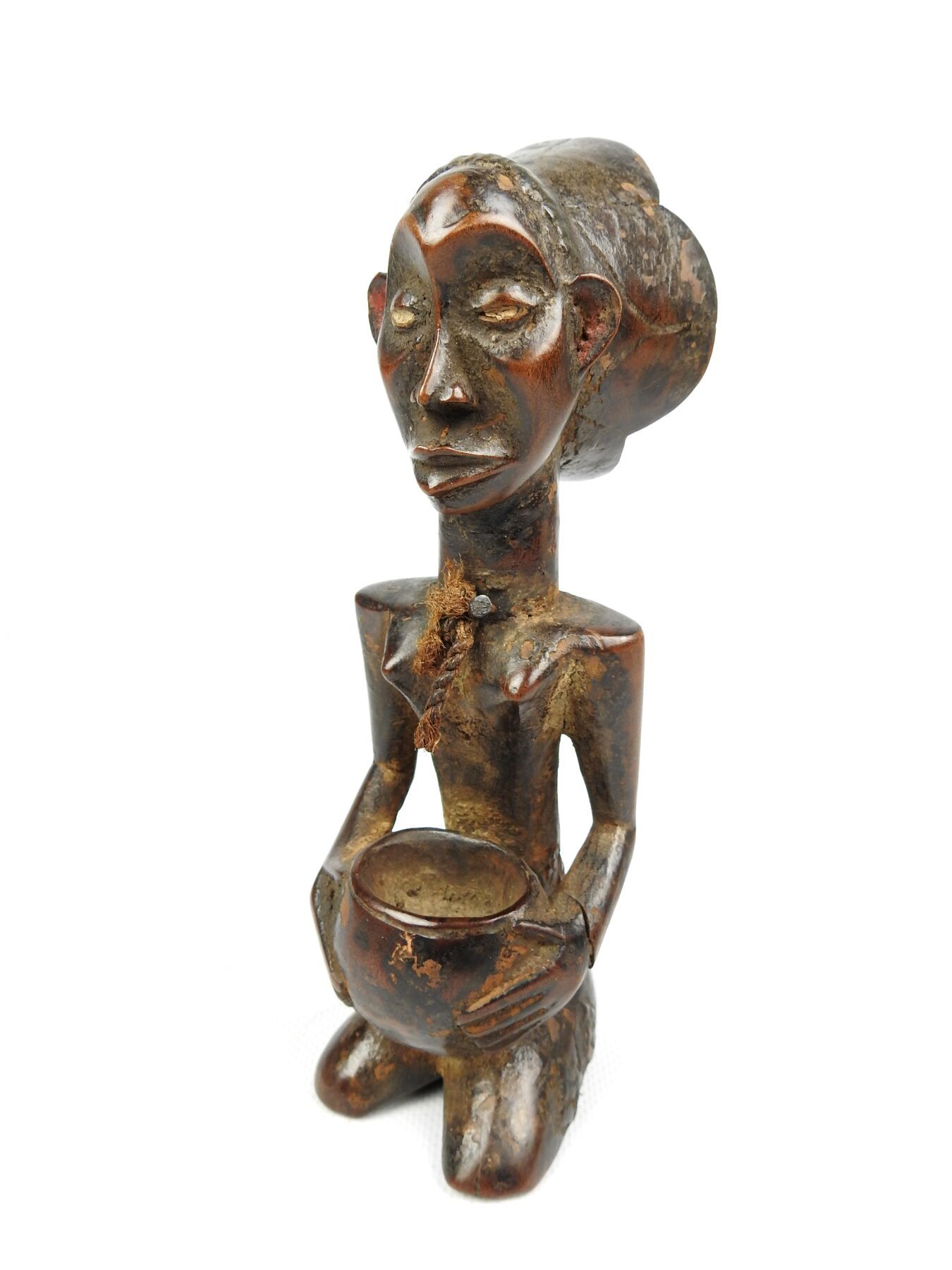 Null 尼日利亚，YOROUBA。
雕刻和抛光的硬木。
杯子的载体，显示一个跪着的女人，手里拿着一个杯子。
高度：21厘米。
裂缝。