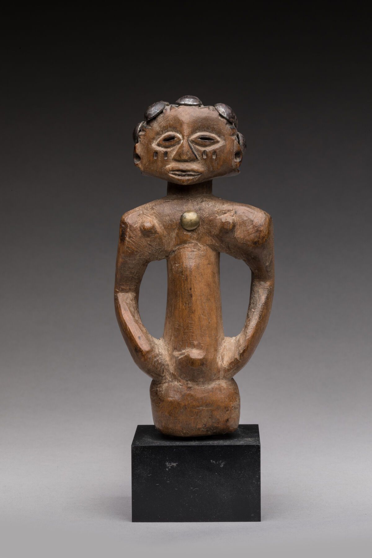 Null LUBA，刚果民主共和国。
木头，自然风化，装饰用钉子。
女性半身雕像，臀部，头饰由金属钉制成。
高度：13厘米。