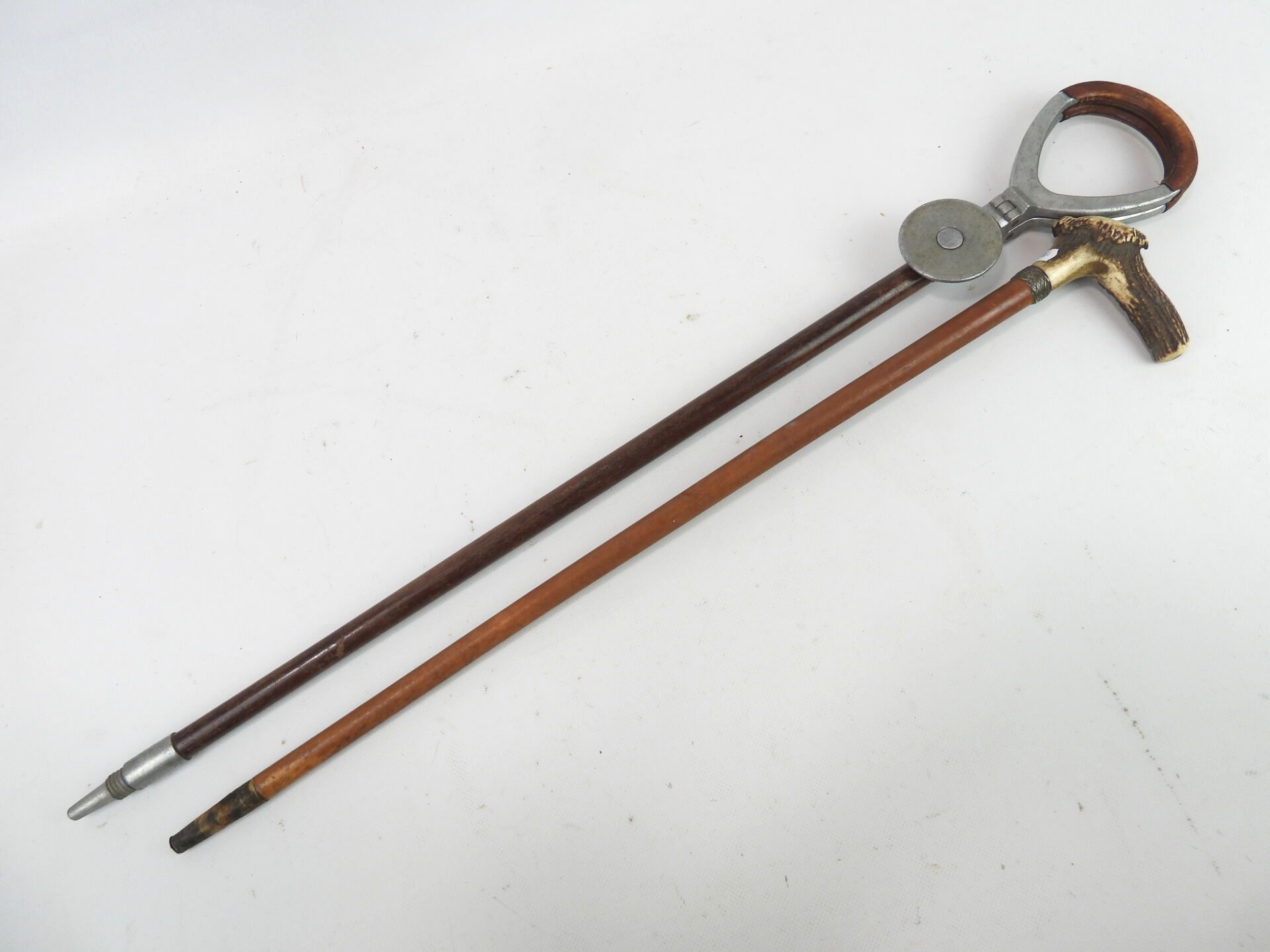 Null 木头、皮革和金属打手杖。高度：84厘米。磨损的

一根带鹿钮的手杖。高度：69厘米。