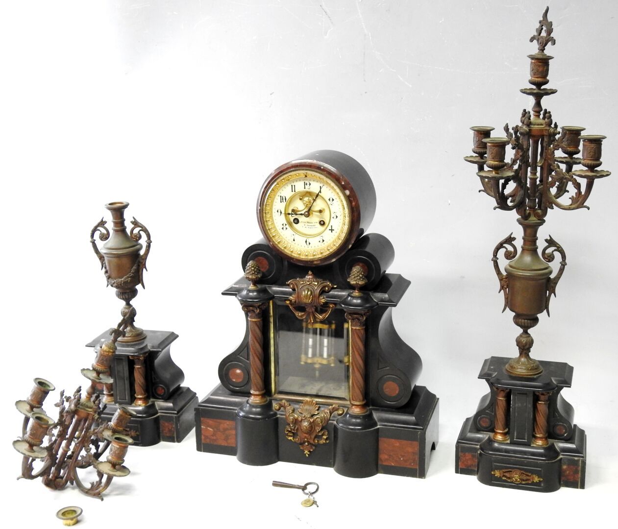 Null 黑色和红色的大理石壁炉套装与青铜器包括:

一个大型终端时钟。带钥匙。52 x 41 x 14.5厘米。

一对有四盏灯的烛台。高度：75.5厘米。
&hellip;