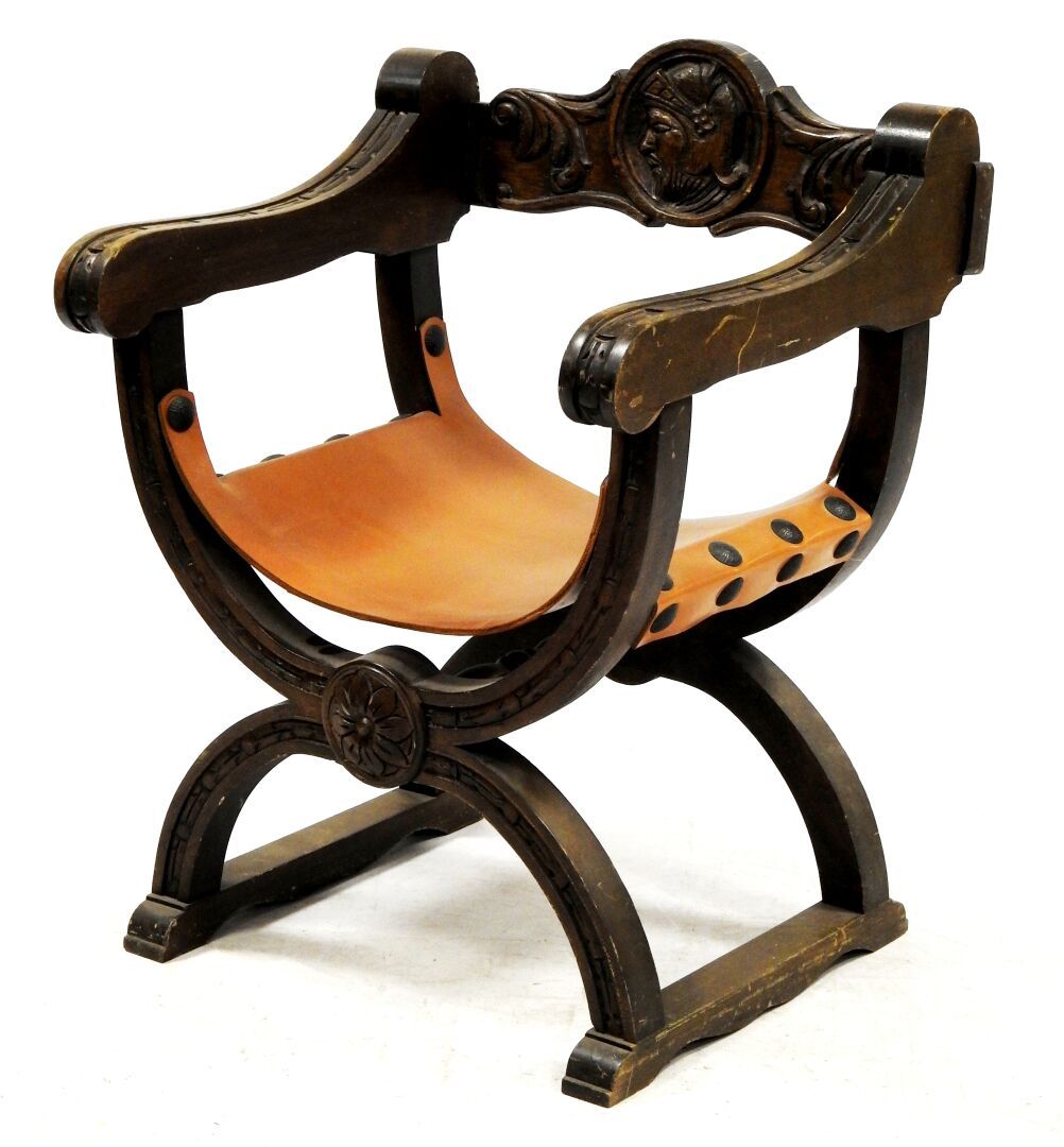 Null 雕刻的天然木质卷曲扶手椅，装饰有叶子和代表骑士的奖章，座椅为棕色皮革。

79 x 59,5 x 53 厘米

磨损，事故。