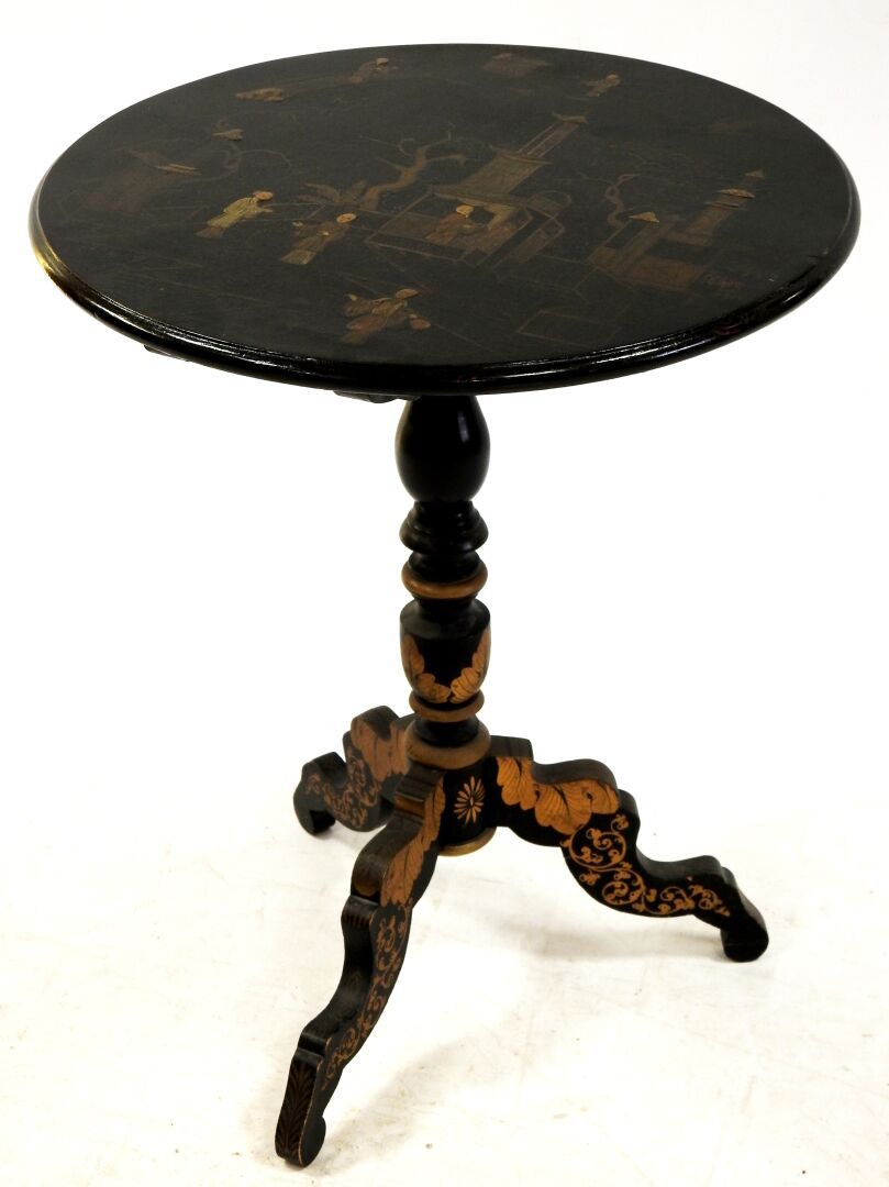 Null 一张发黑的木质三脚架基座桌，倾斜的圆形桌面上装饰着亚洲的宫殿场景。

高：71厘米；直径：56.5厘米。

磨损和撕裂。